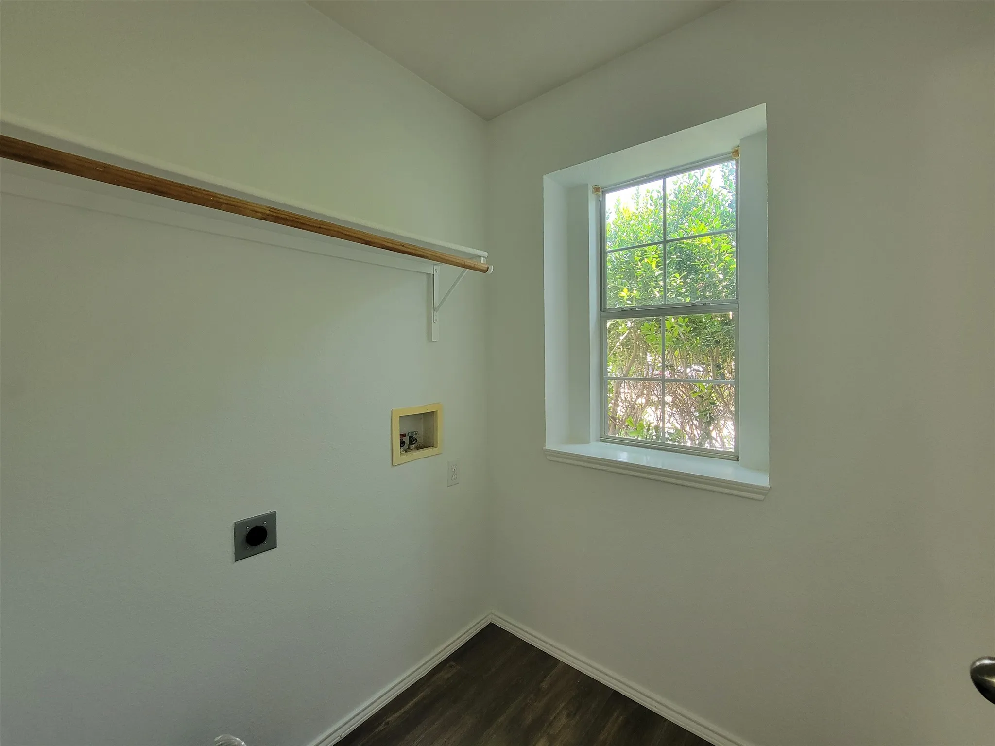 Utility room featuring wood-finish flooring and a single-pane window