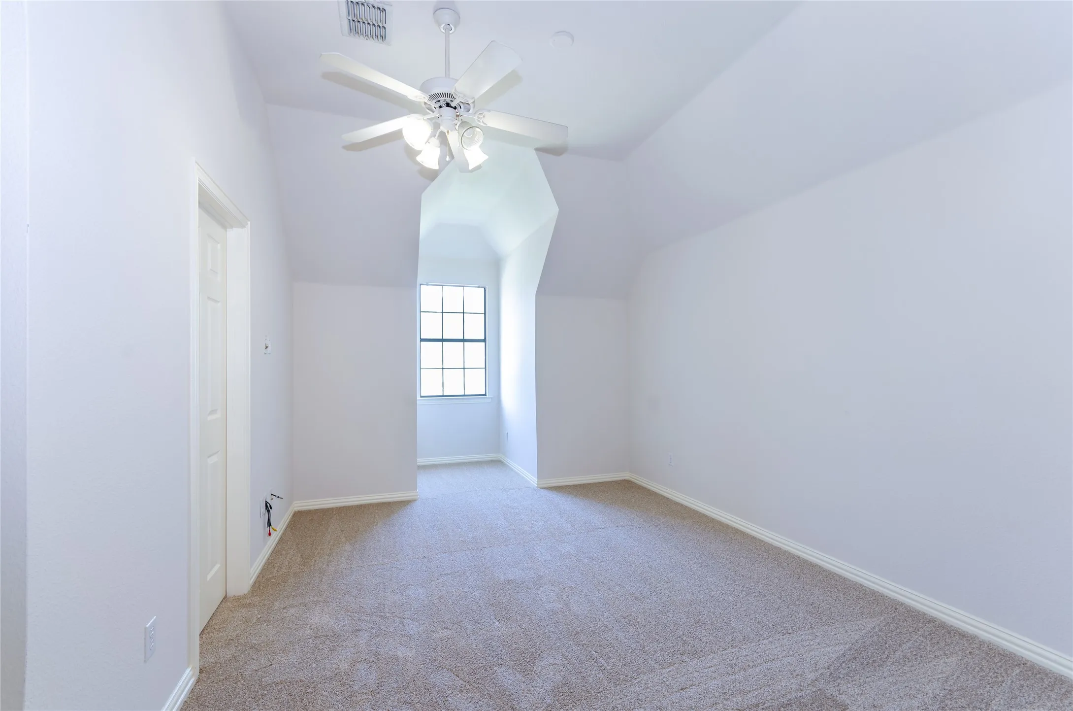 Bedroom # 5 Carpeted interior space featuring a multi-pane window, sloped ceilings, and a ceiling fan with integrated lighting