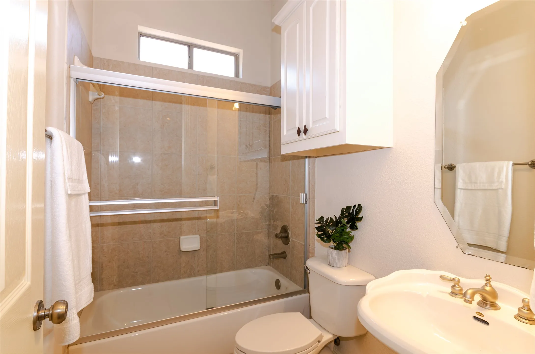 Bathroom #2, full bath with a pedestal sink, toilet, and shower / bath combination with glass door