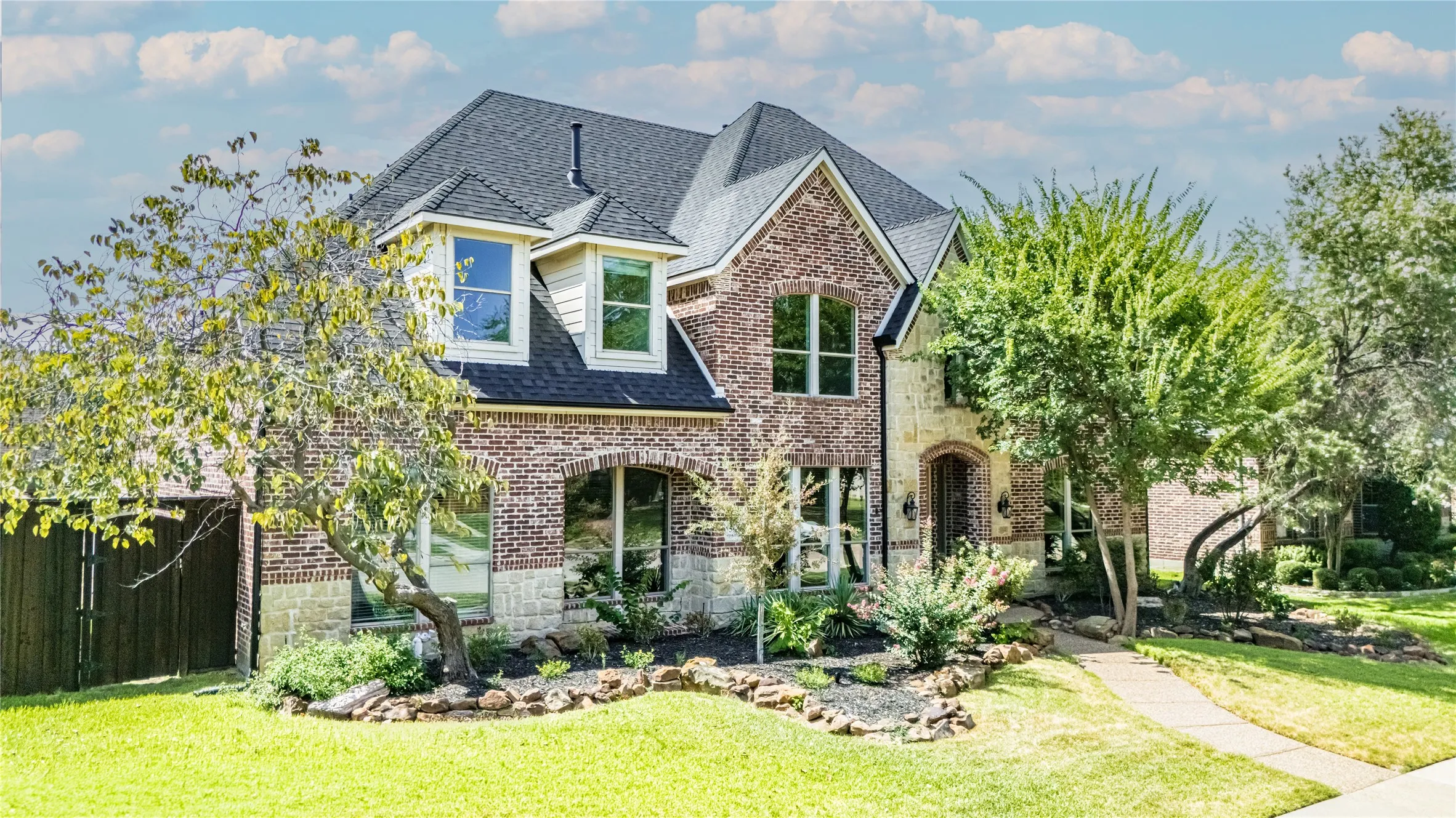Two-story residence featuring a brick and stone facade