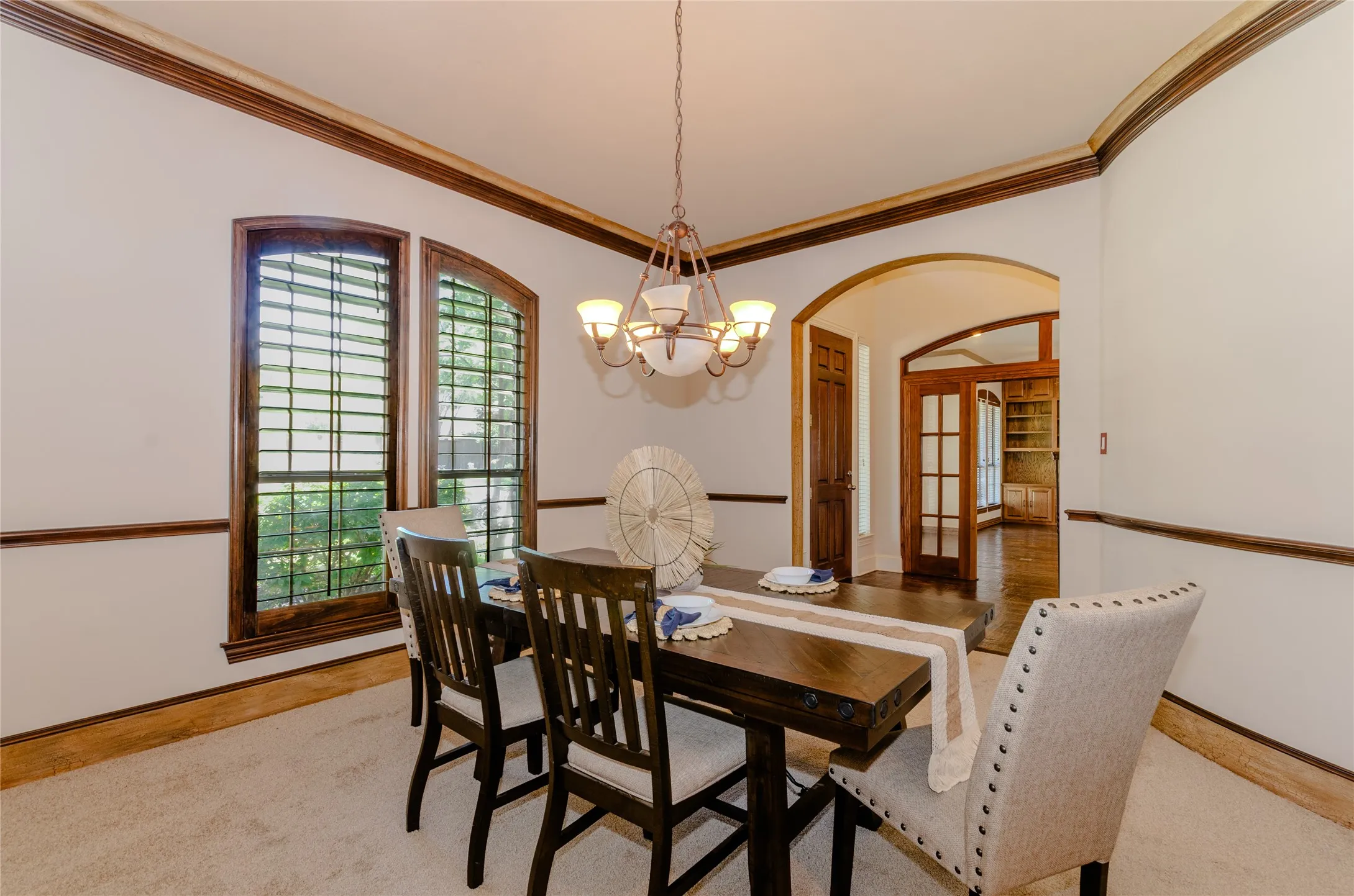 Formal dining room featuring a chandelier, ornamental molding, and arched walkways