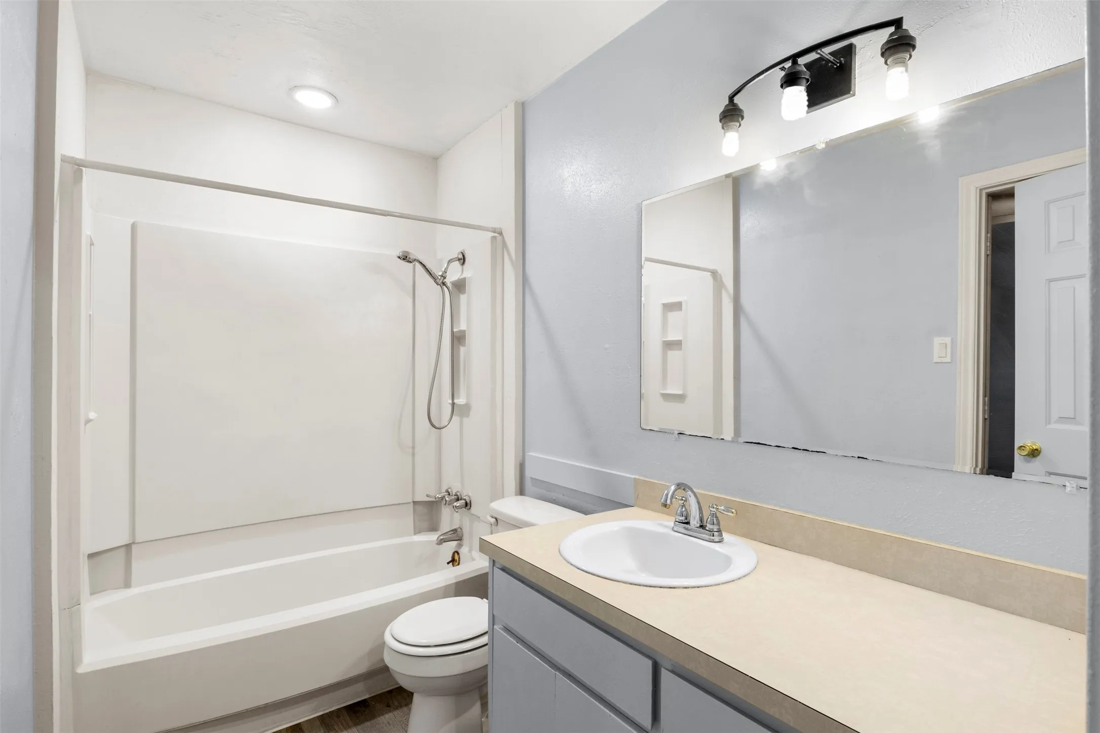 Bathroom featuring a white bathtub and shower combination with a bright white surround