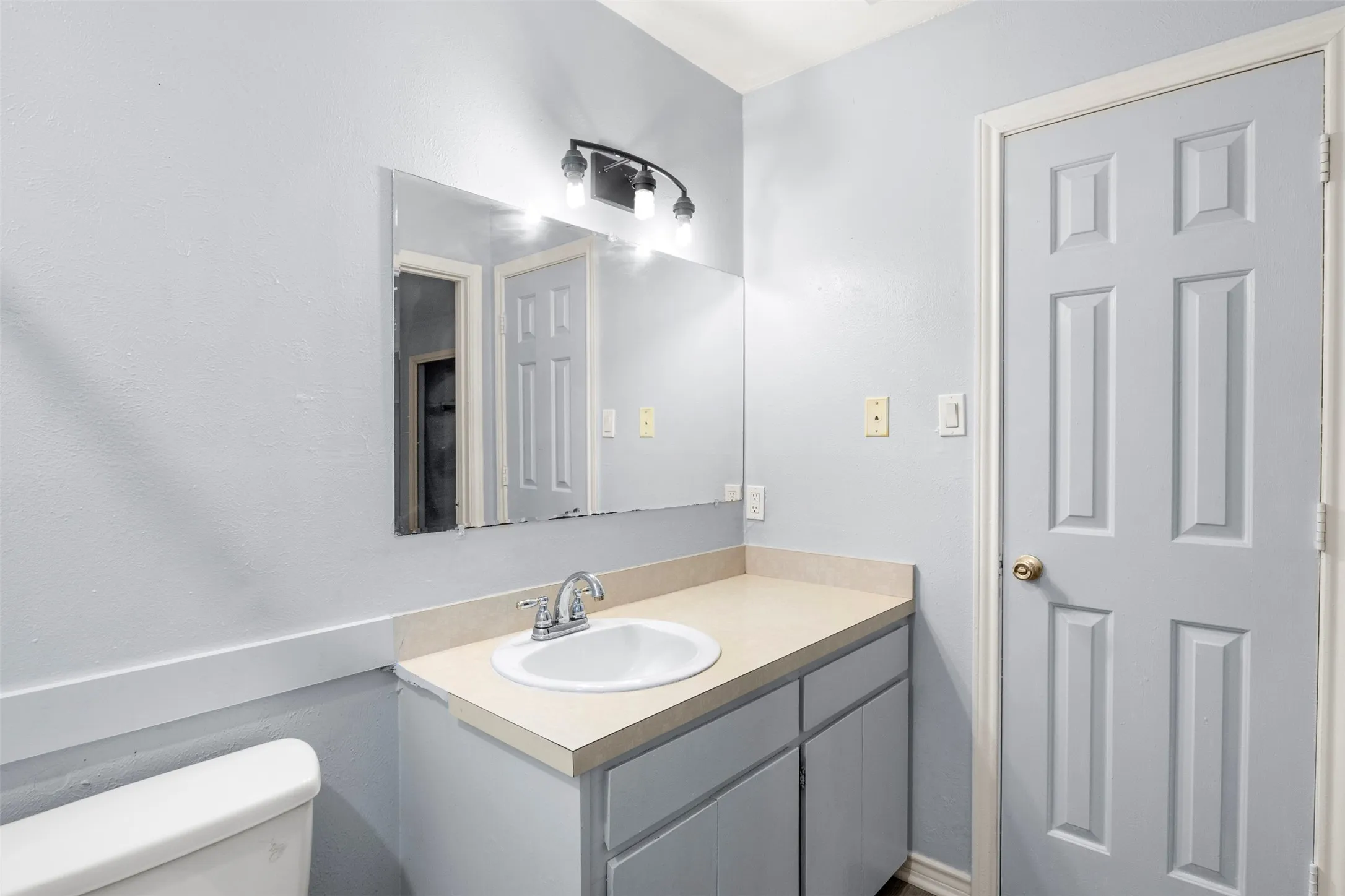Vanity featuring a built-in sink, chrome faucet, and overhead lighting