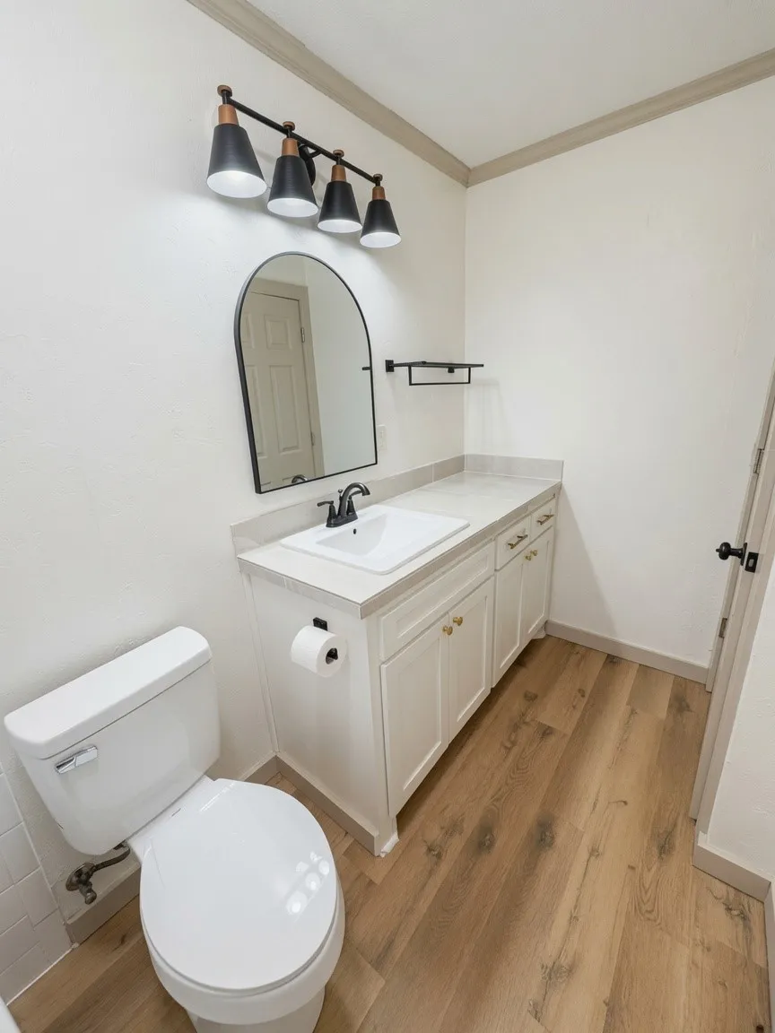 Bathroom featuring a single vanity with an integrated sink, light-toned countertop, and white cabinetry