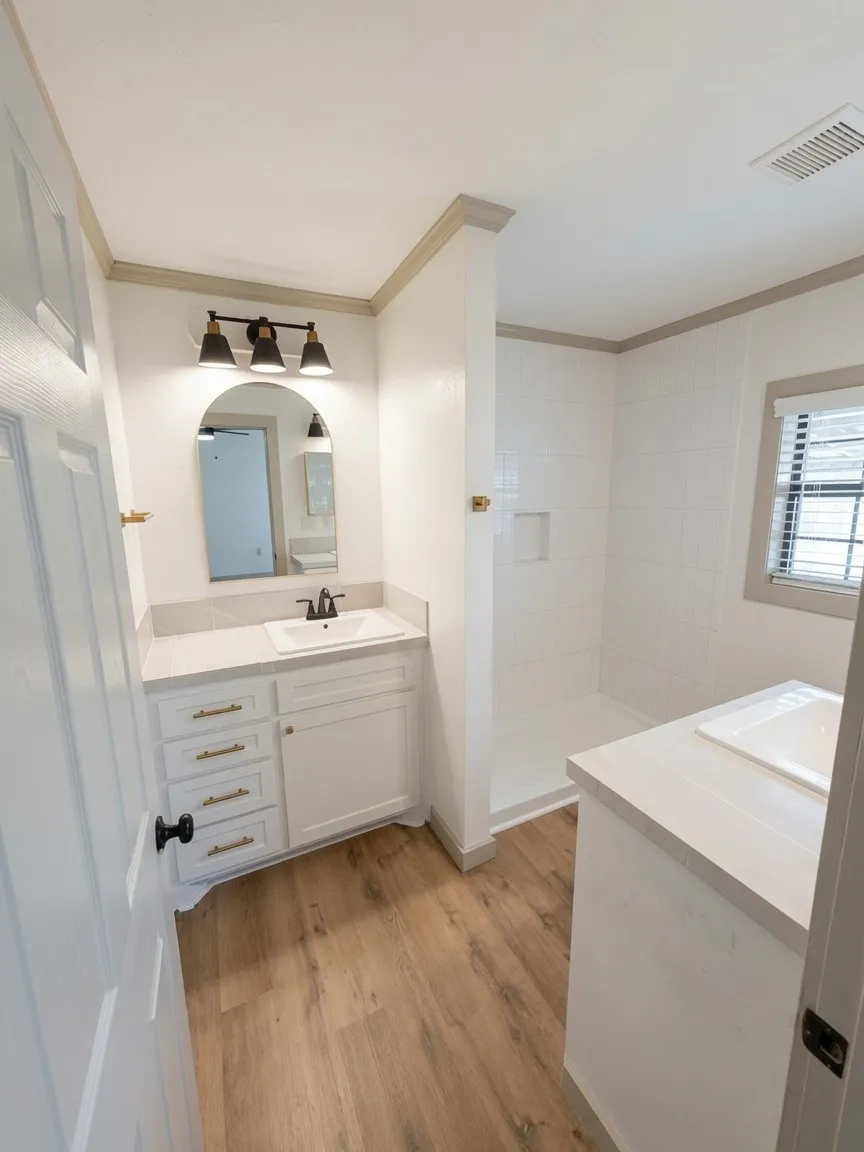 Bathroom featuring wood-finish flooring, a white vanity with a light-colored countertop, and an integrated sink