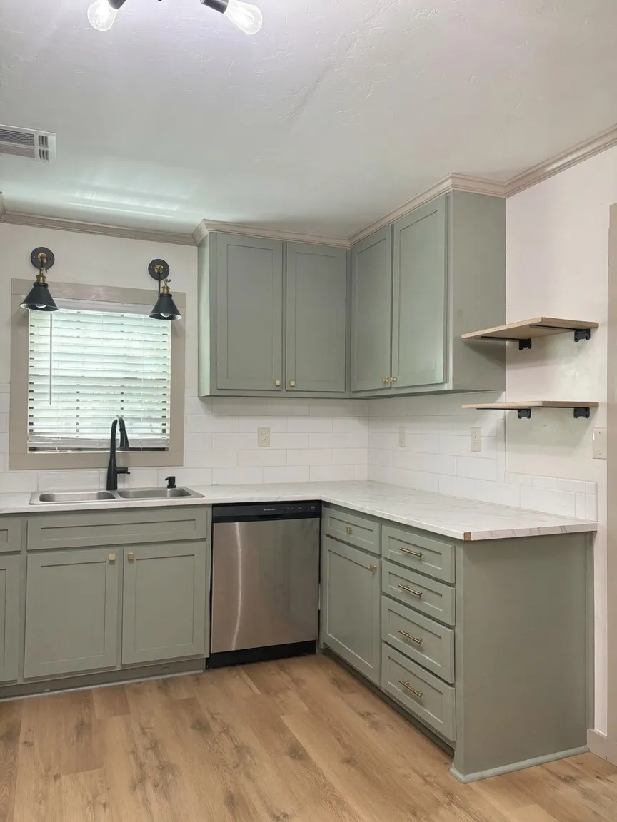 Kitchen featuring sage cabinetry, white countertops, subway tile backsplash, stainless steel dishwasher, and wood-finish flooring
