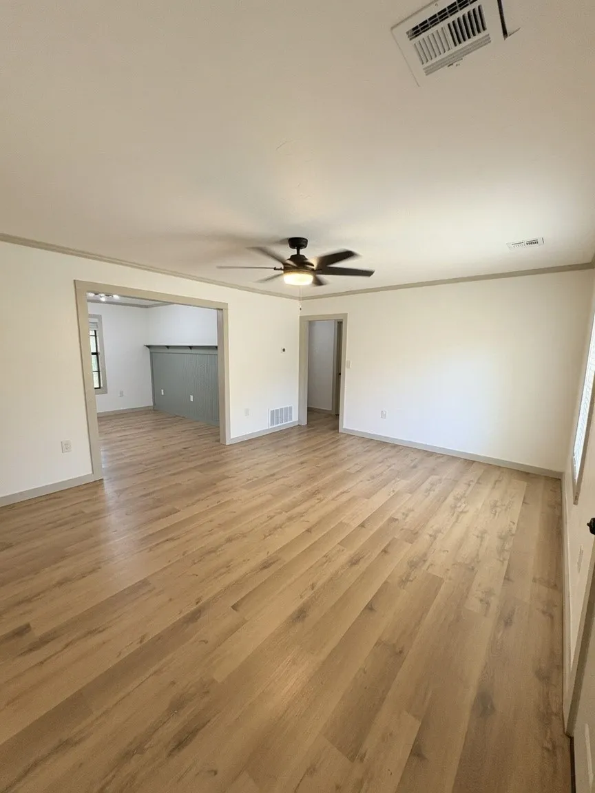 Spacious living room opening up into dining room and kitchen