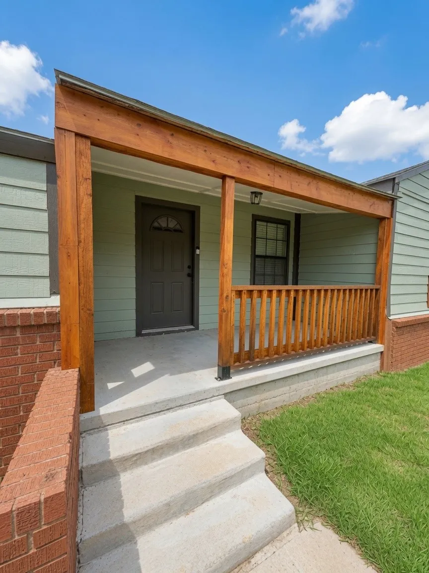 Covered front porch featuring natural wood columns and railing