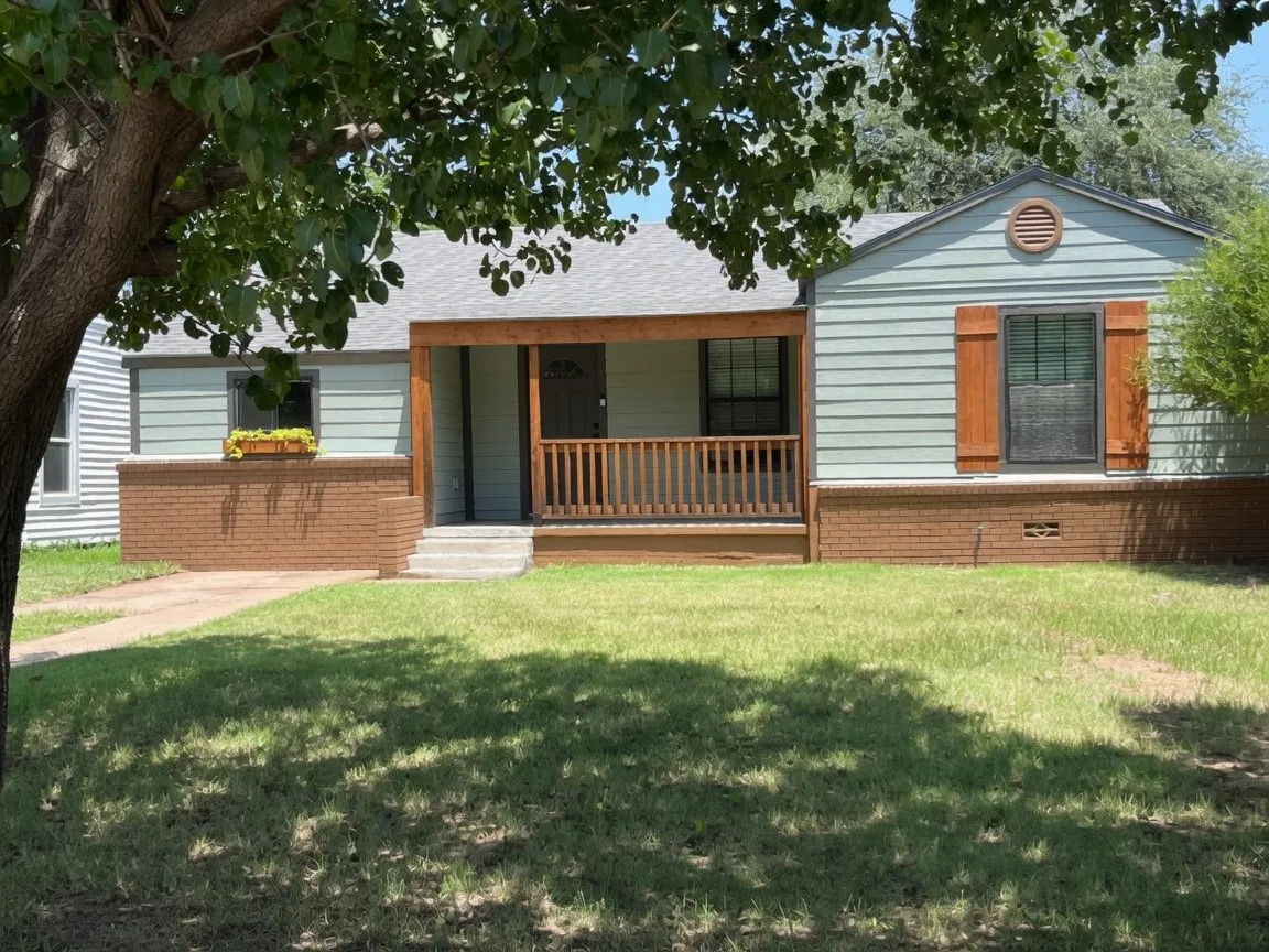 Light blue siding exterior with a welcoming covered porch featuring natural wood posts and railing