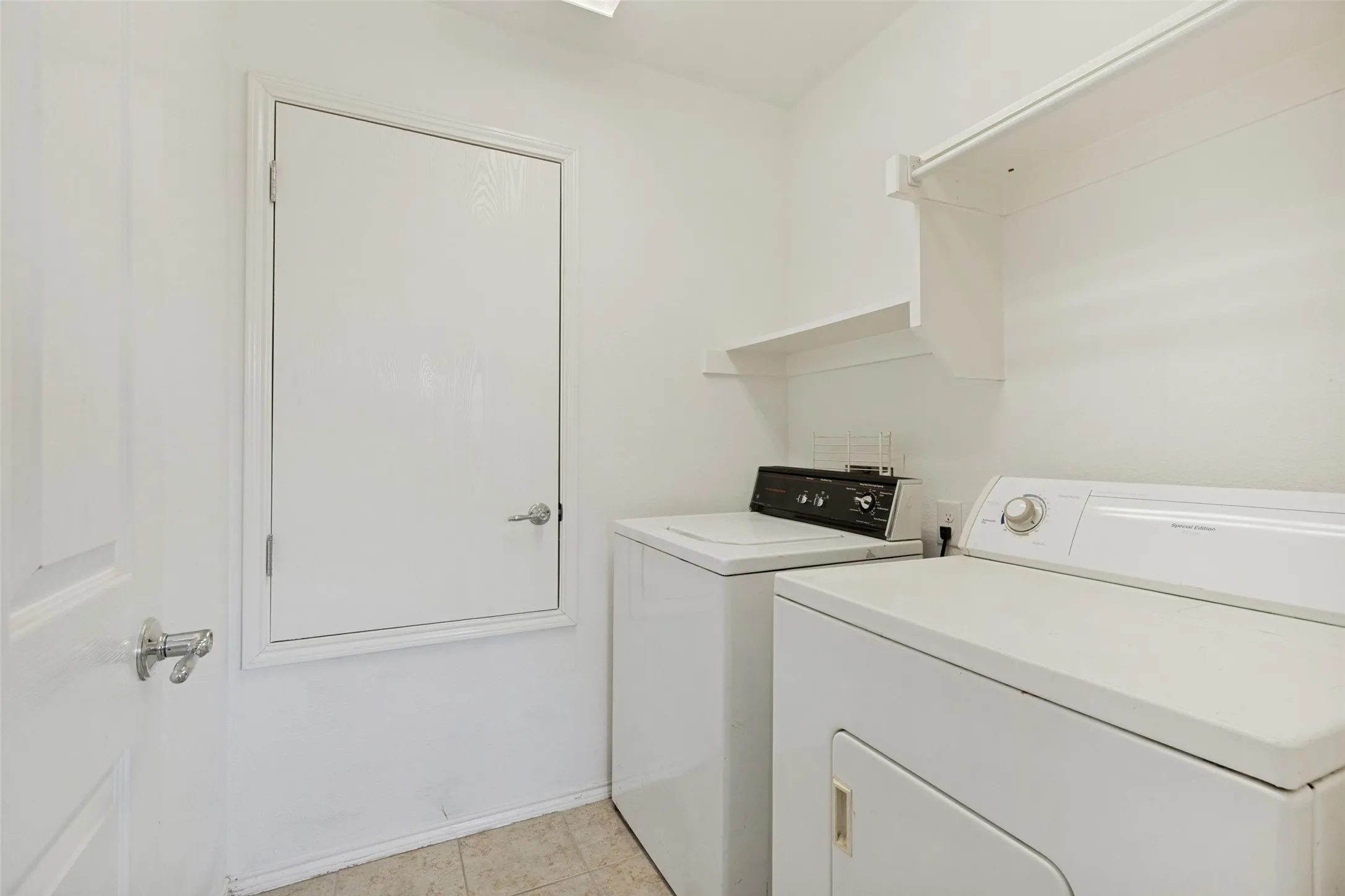 Utility area featuring white walls, a white ceiling, and tiled flooring