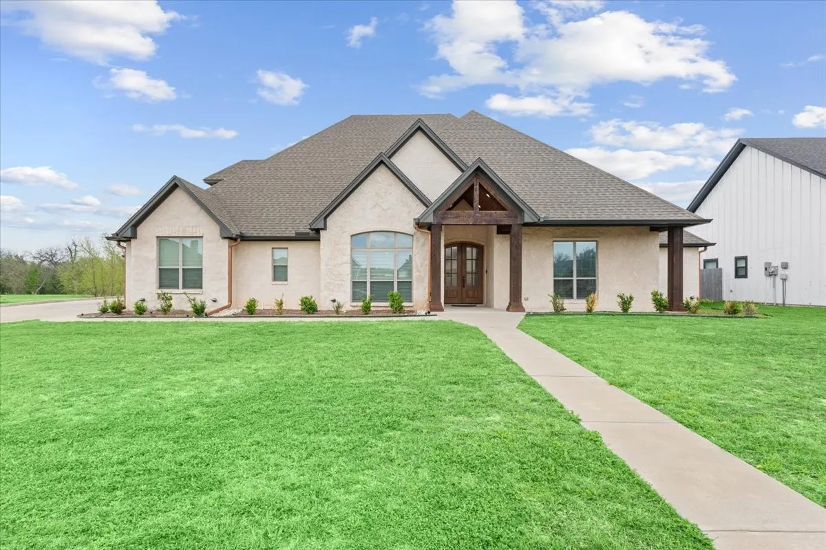 Exterior showcasing light-colored brick and stucco with dark trim accents