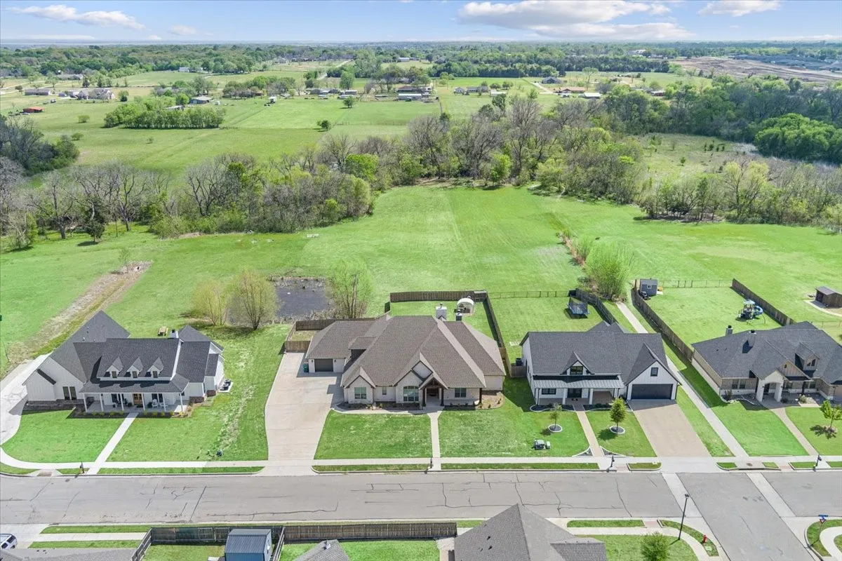 Aerial perspective showcasing a residential property with a vast green expanse