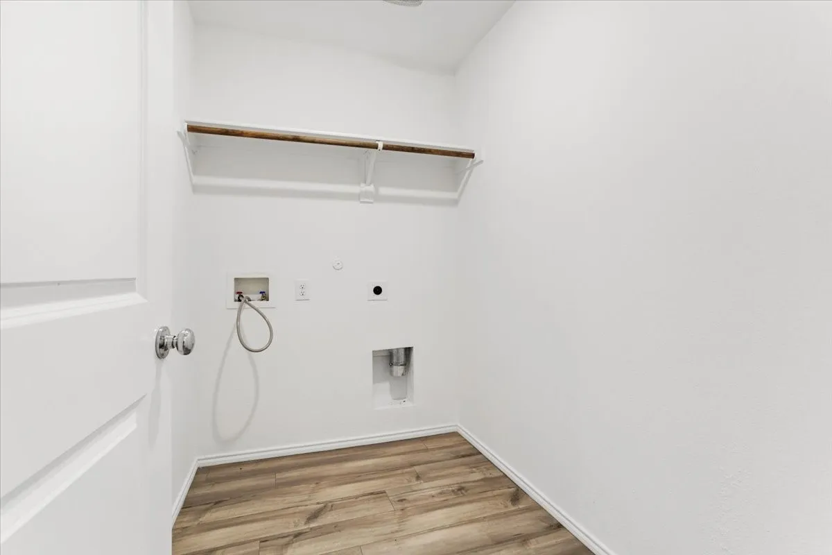 Primary Bathroom Featuring Chrome Fixtures and Wood-Finish FlooringThis spa-inspired bathroom showcases modern chrome hardware, including a wall-mounted handheld showerhead and integrated fixtures