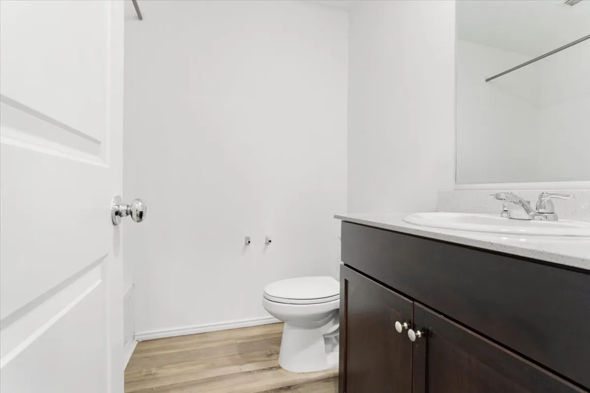 Contemporary bathroom featuring a dark wood vanity with ample storage, white quartz countertop, and chrome fixtures