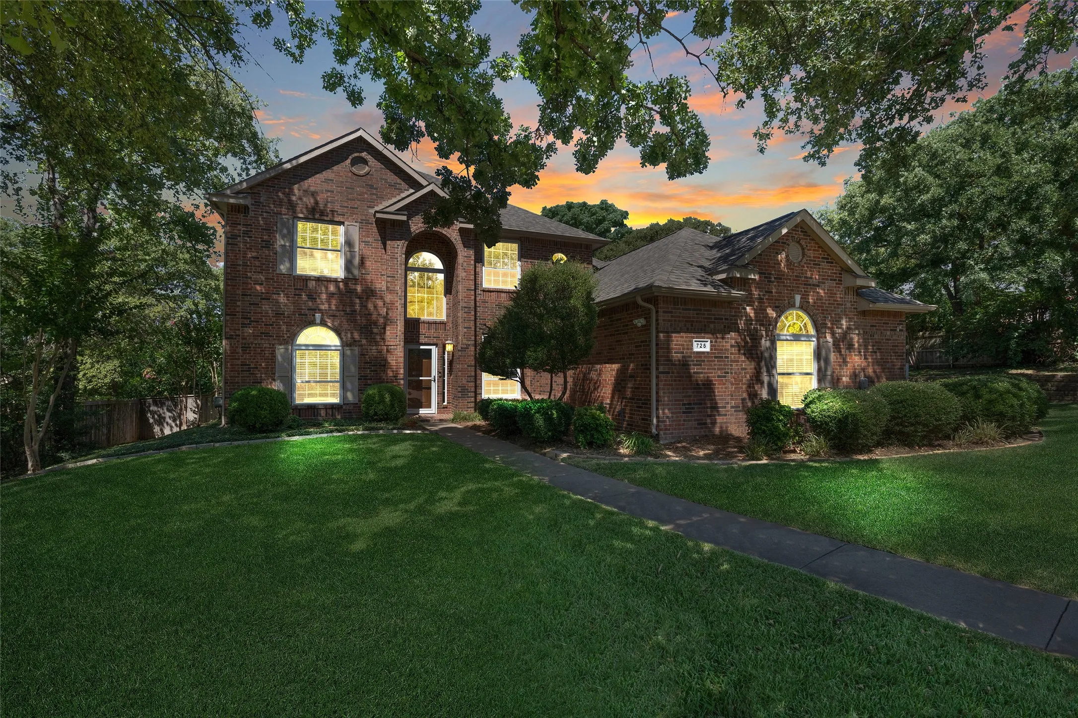 Brick exterior with a dark shingle roof and arched window details