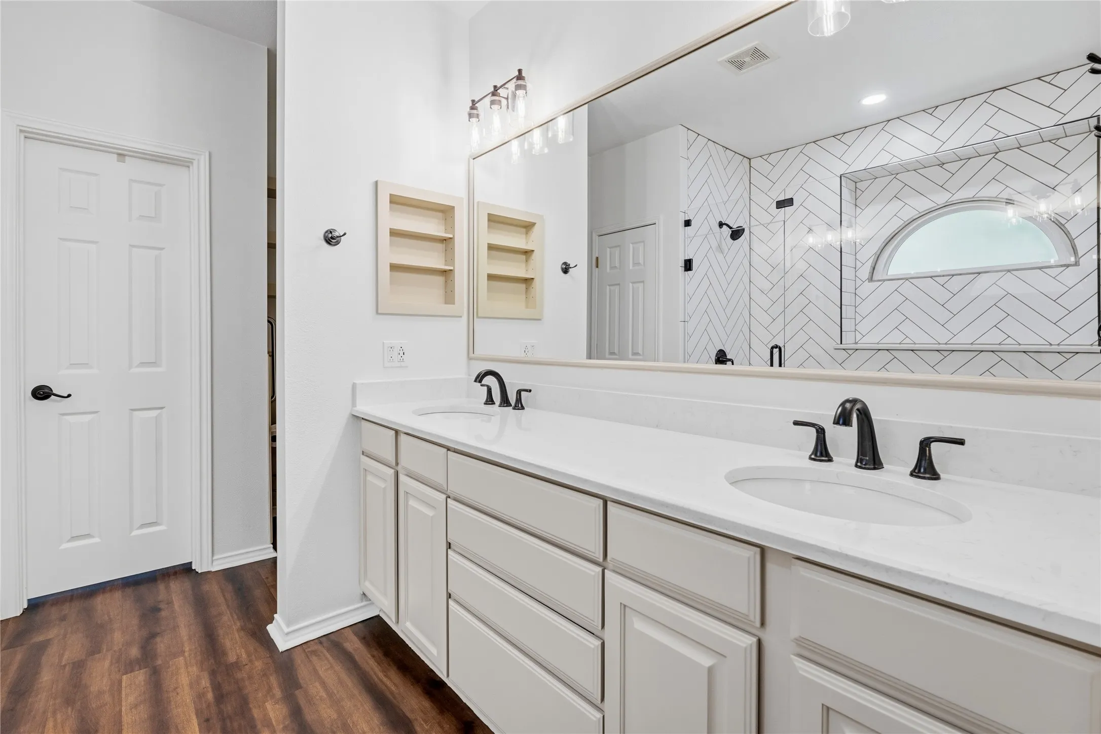 Dual vanity with white shaker-style cabinetry, white countertops, and matte black fixtures