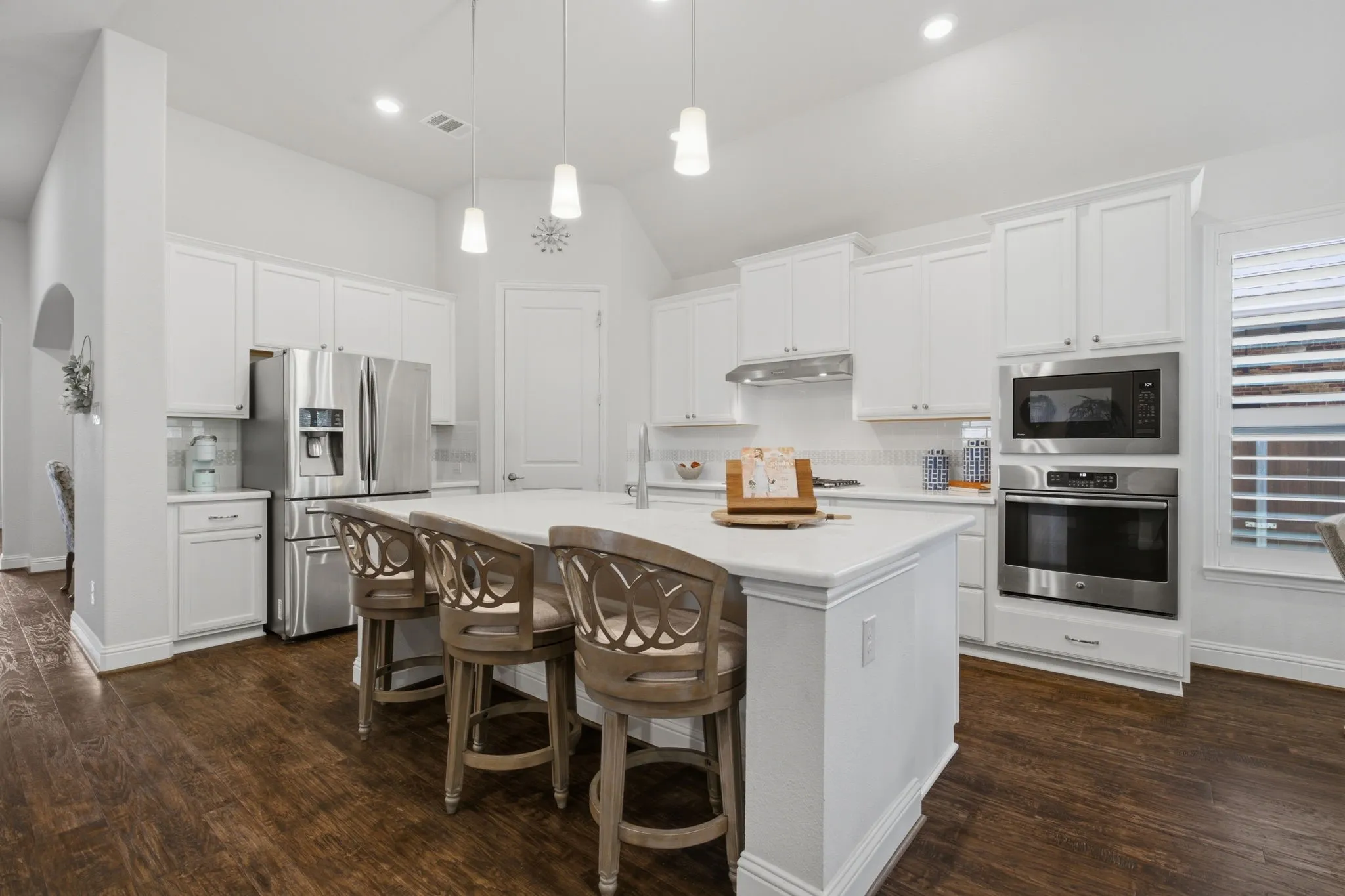 Hardwood Floors run throughout the home. Quartz Island, SS Appliances, 5 Burner Gas Cooktop, refrigerator conveys with the home.