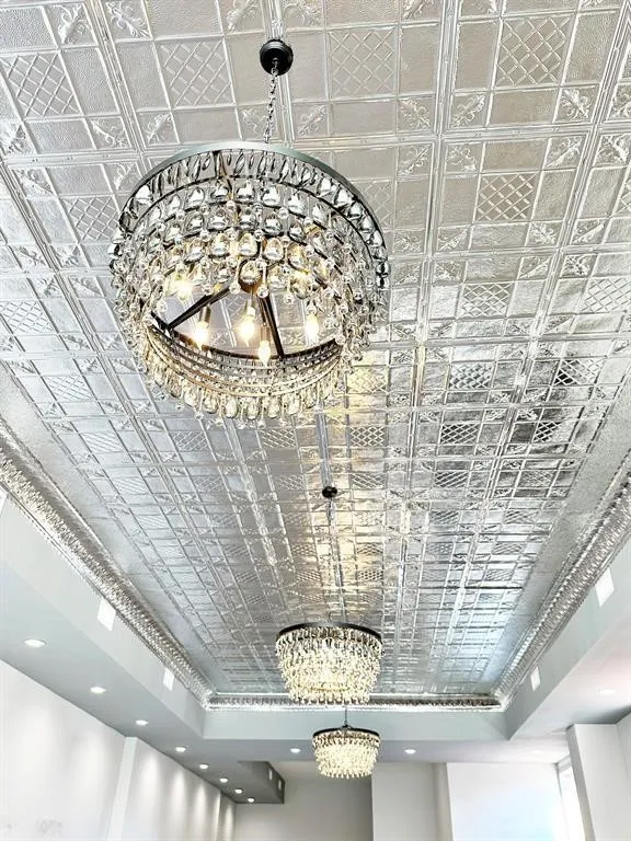 Ornate patterned ceiling tiles featuring multiple crystal chandeliers