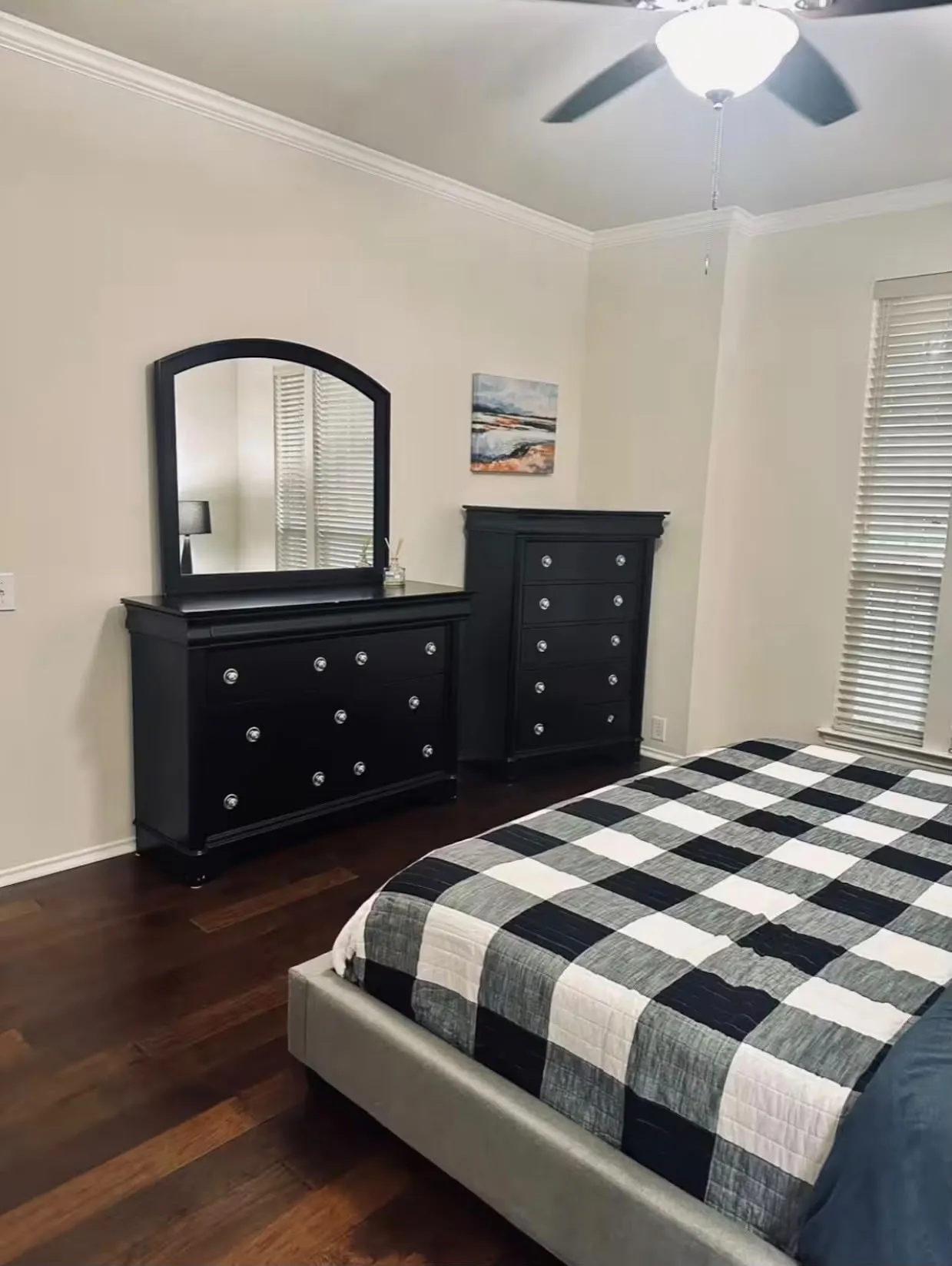 Spacious room featuring wood-finish flooring, crown molding, a ceiling fan with integrated lighting, and a window with horizontal blinds