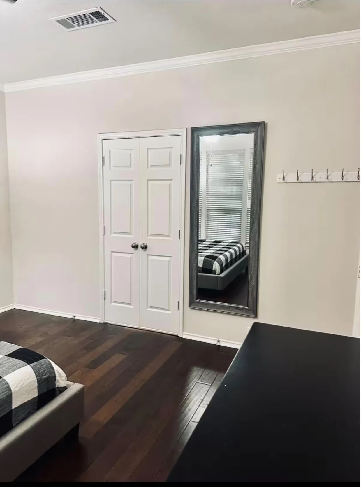 Bedroom featuring dark wood-finish flooring, white walls, and bright white trim