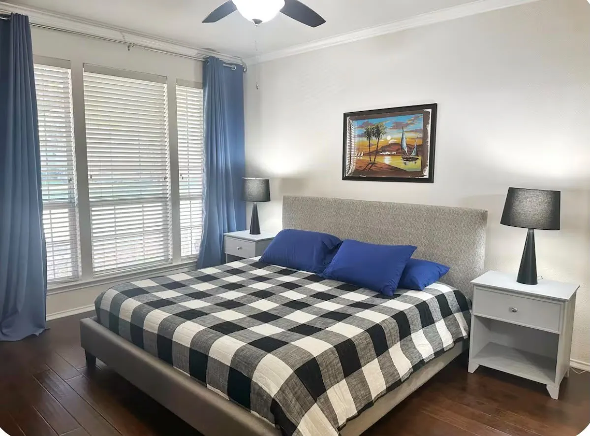 Room featuring dark wood-finish flooring, white crown molding, and a ceiling fan with integrated lighting