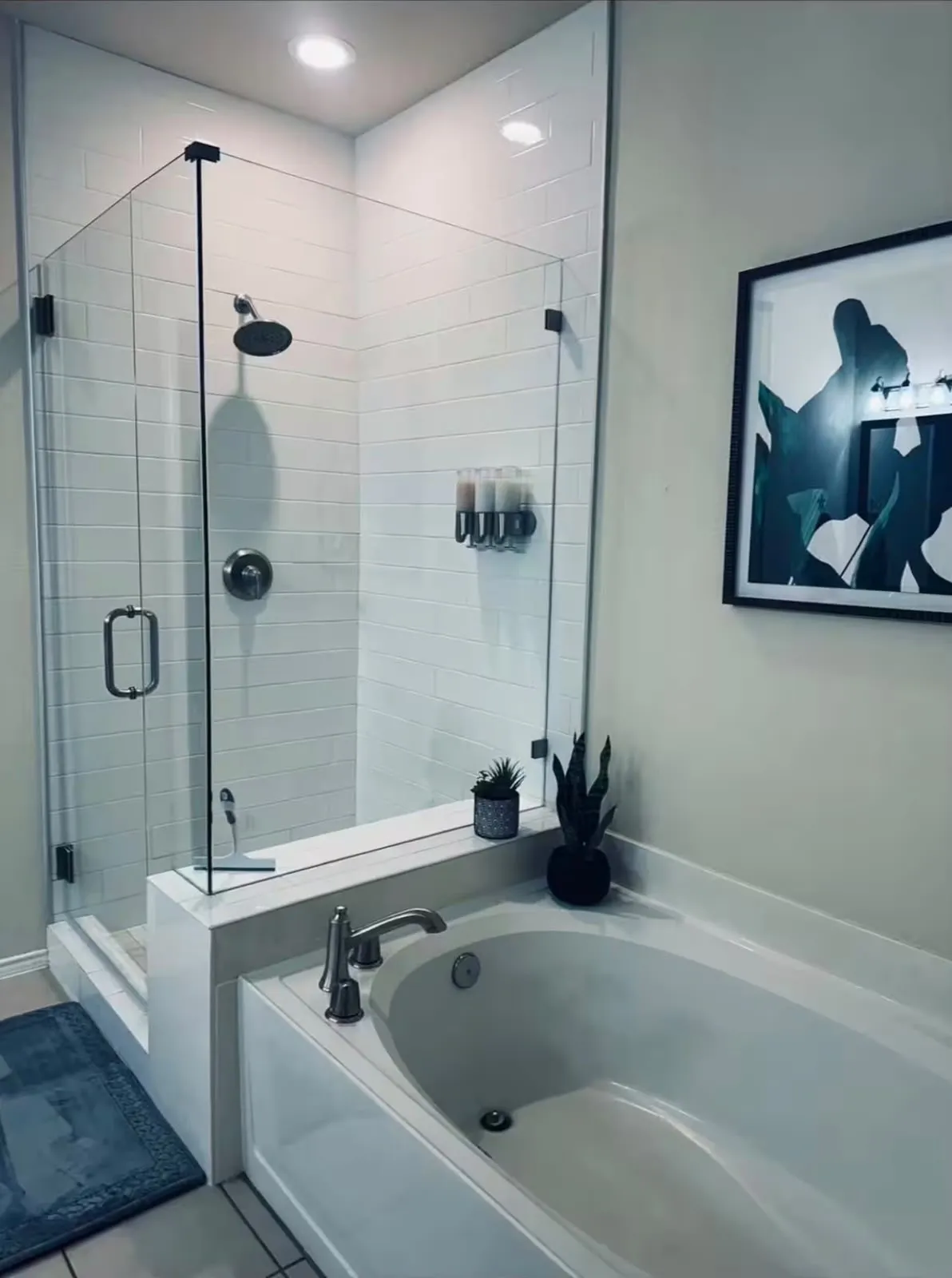 Glass-enclosed shower with subway tile surround, rain showerhead, and matte black hardware