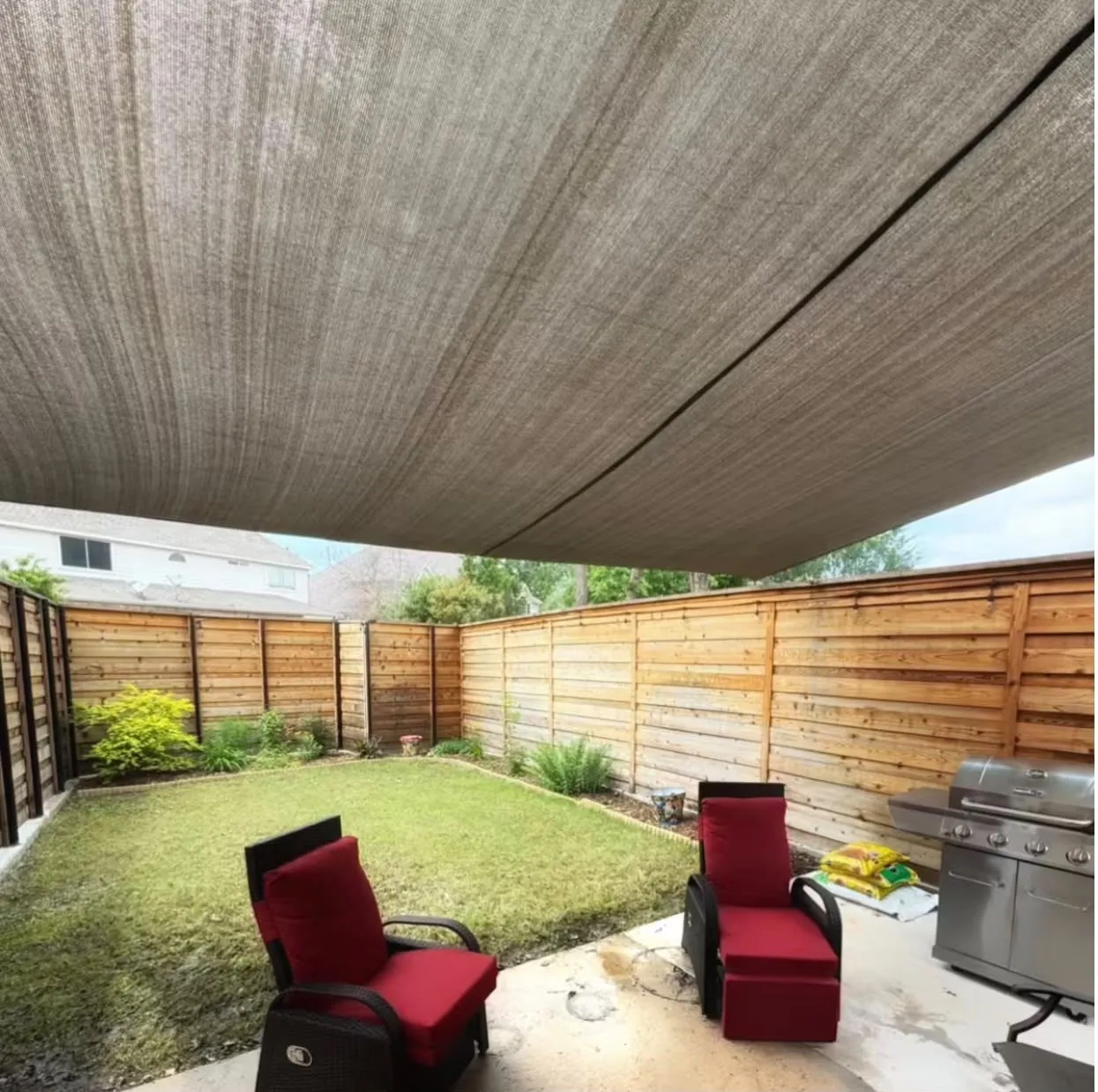 Patio area featuring an overhead shade structure, concrete flooring, and a privacy fence