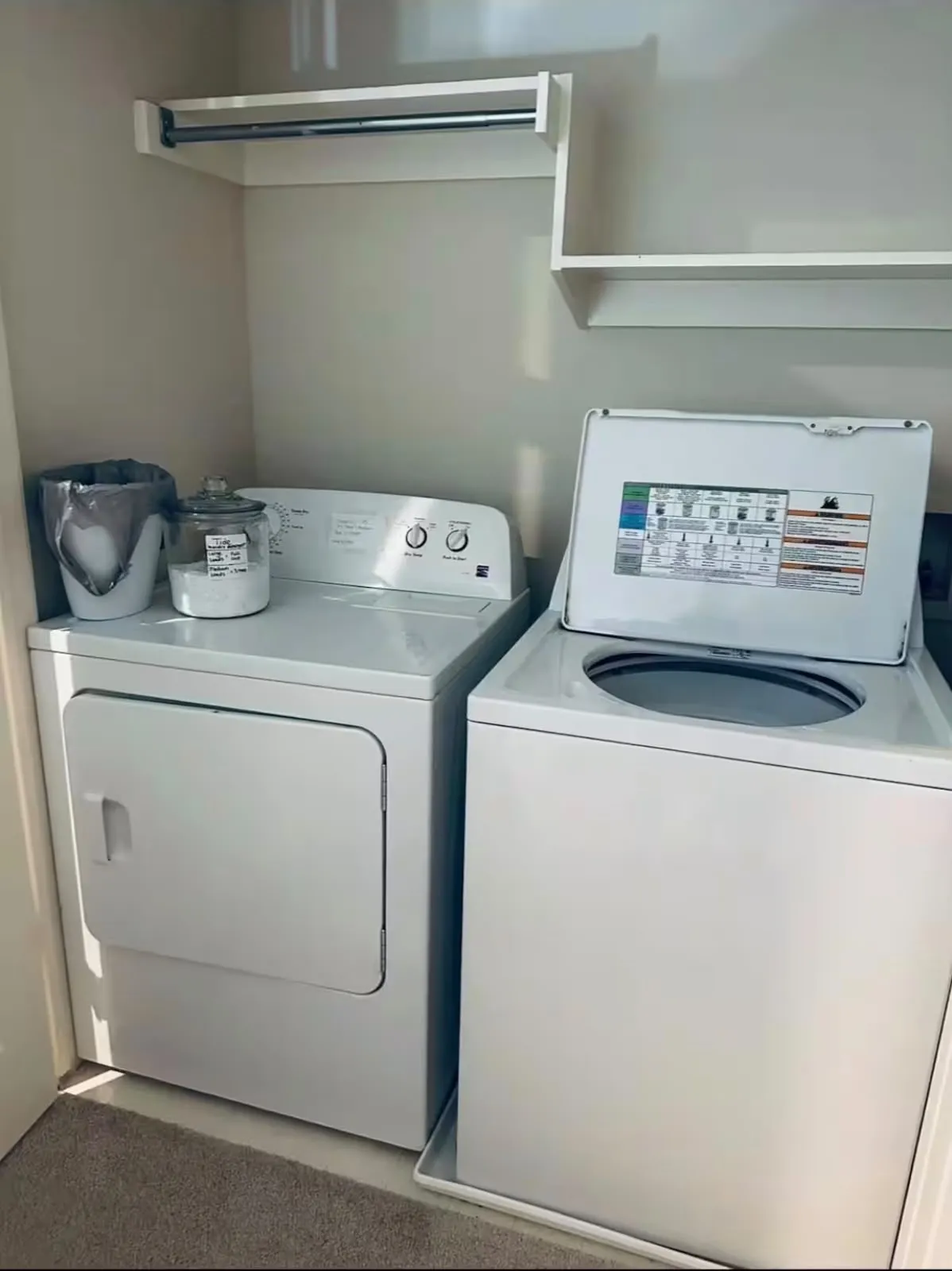Dedicated laundry area featuring a white top-load washing machine and a white front-load dryer