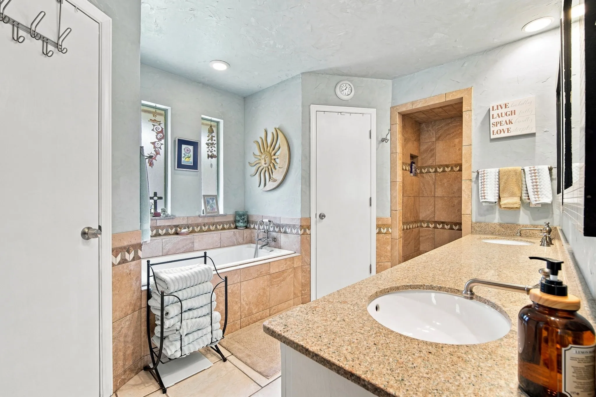 Bathroom featuring an integrated soaking tub, a tiled shower, and a dual vanity with undermount sinks