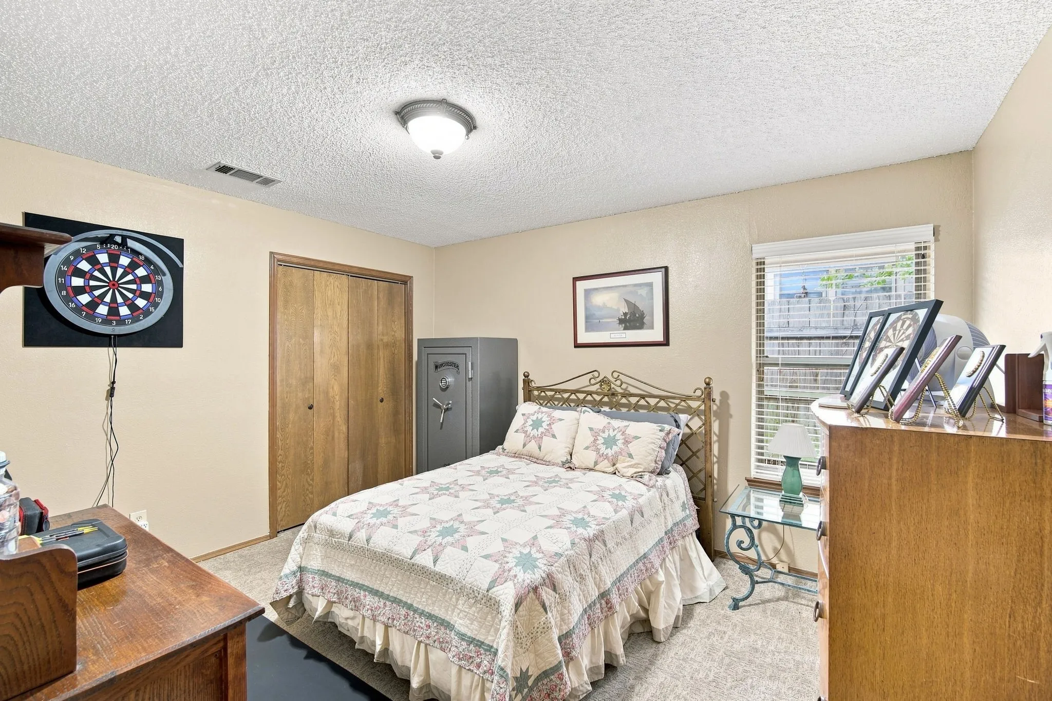 Carpeted room featuring a window with blinds, a ceiling-mounted light fixture, and a closet with bifold wood-finish​​‌​​​​‌​​‌‌​‌‌​​​‌‌​‌​‌​‌​​​‌​​ doors