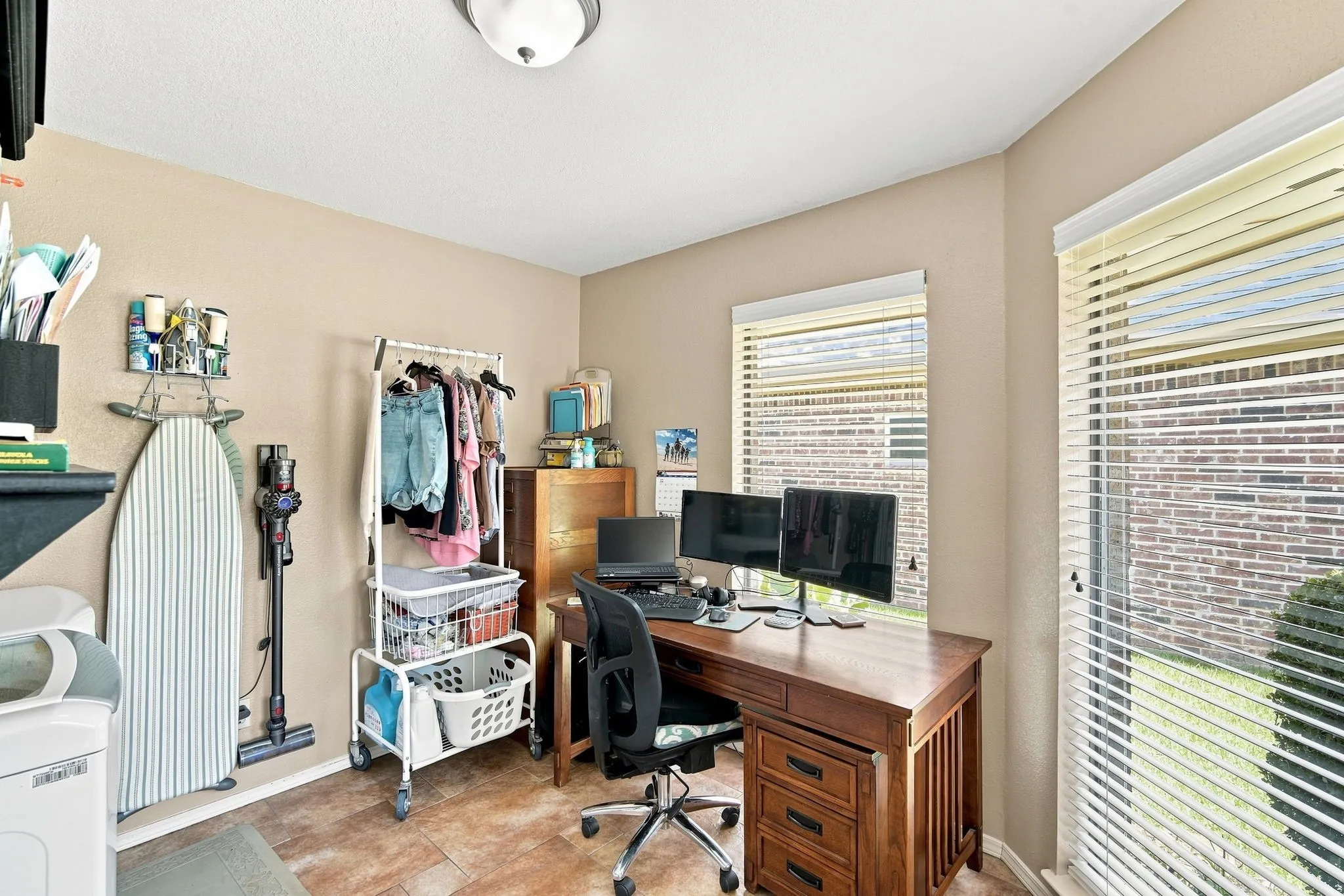 Versatile room featuring tile flooring and two windows with blinds