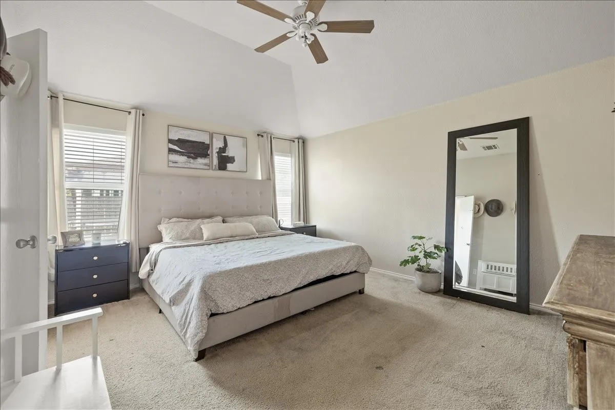 Carpeted room featuring a vaulted ceiling with a fan light fixture