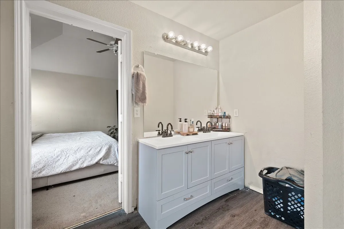 Dual vanity with undermount sinks and light blue cabinetry, featuring a white countertop and wood-finish flooring