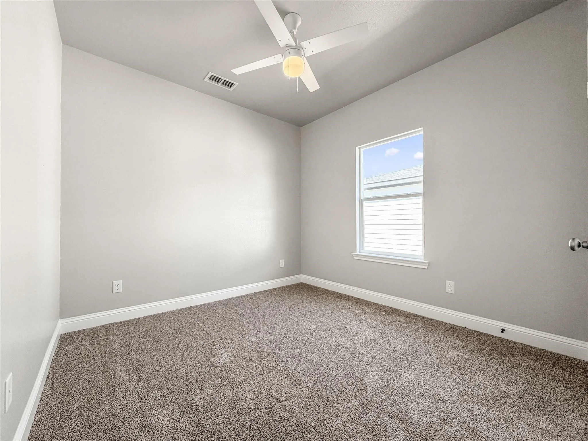 Bedroom featuring neutral-toned walls, plush carpeting, a single window with white blinds, a ceiling fan with integrated lighting, and white baseboards