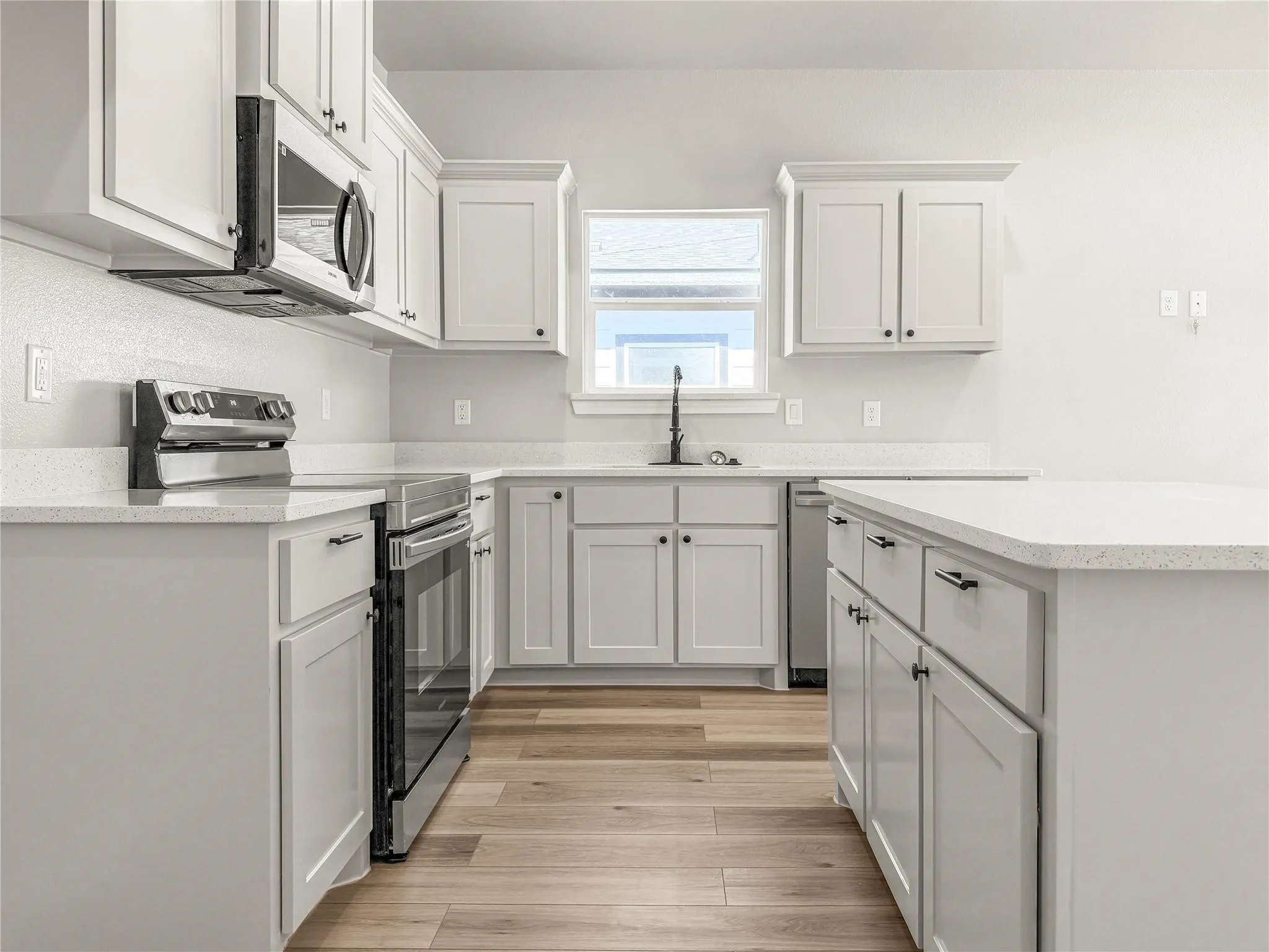 Bathroom featuring a white vanity with a light-colored countertop, an undermount sink, and a matte black faucet