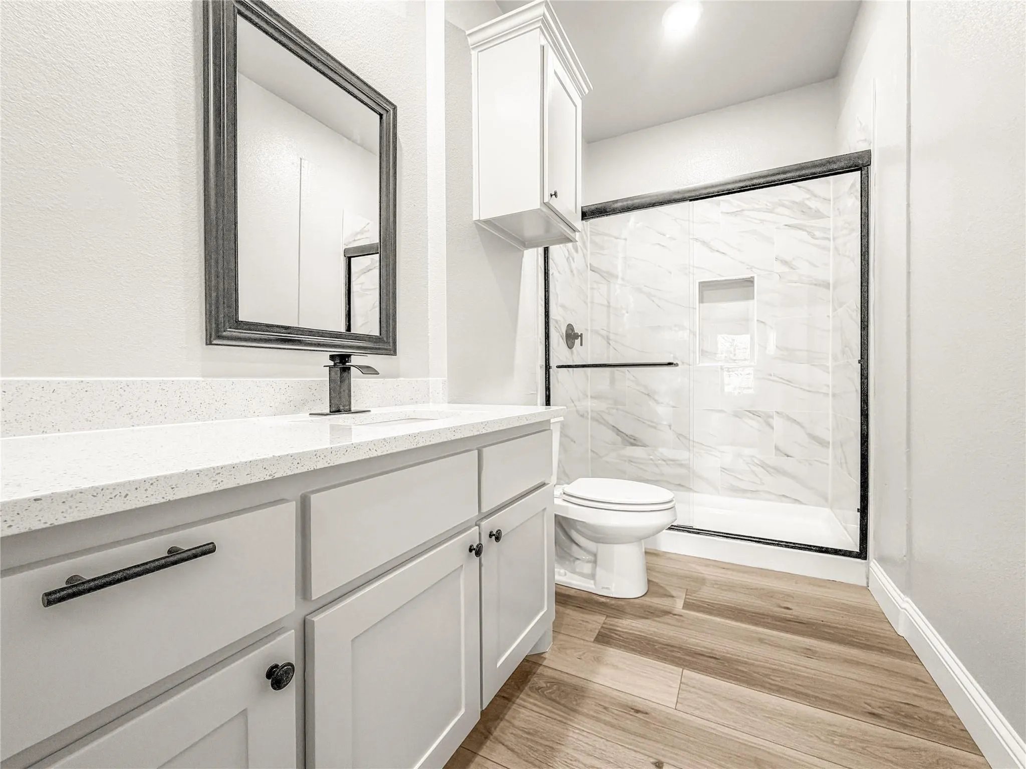 Bathroom featuring a white vanity with quartz-finish countertop, undermount sink, and matte black faucet
