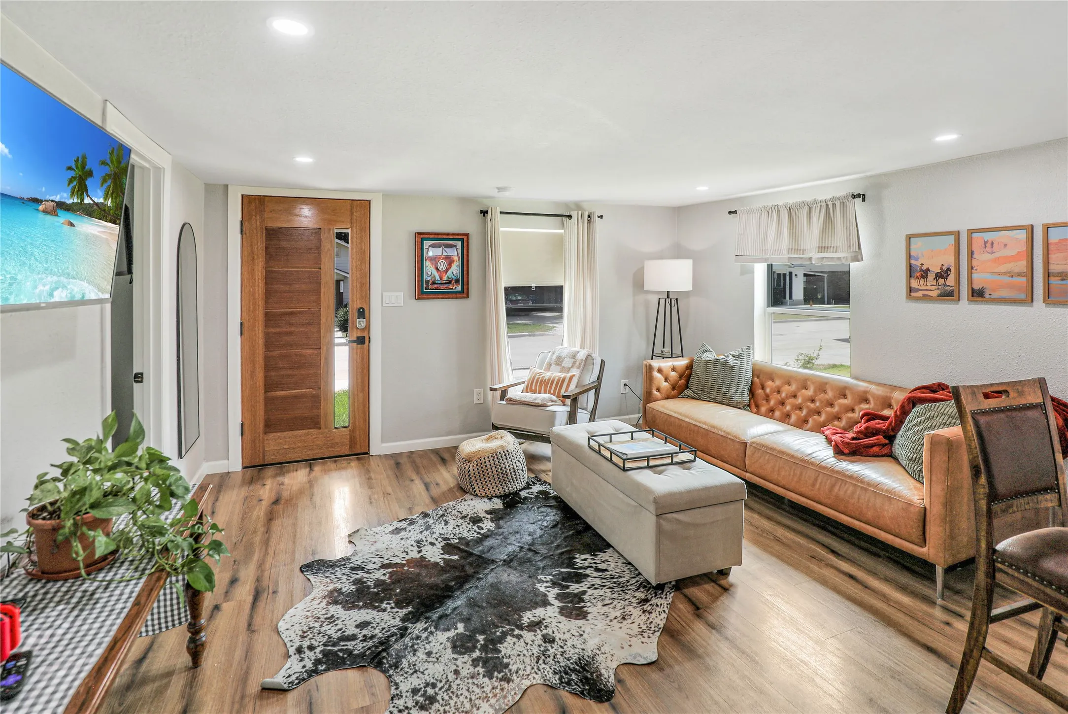 Warm wood-finish flooring complements the light wall color and recessed lighting