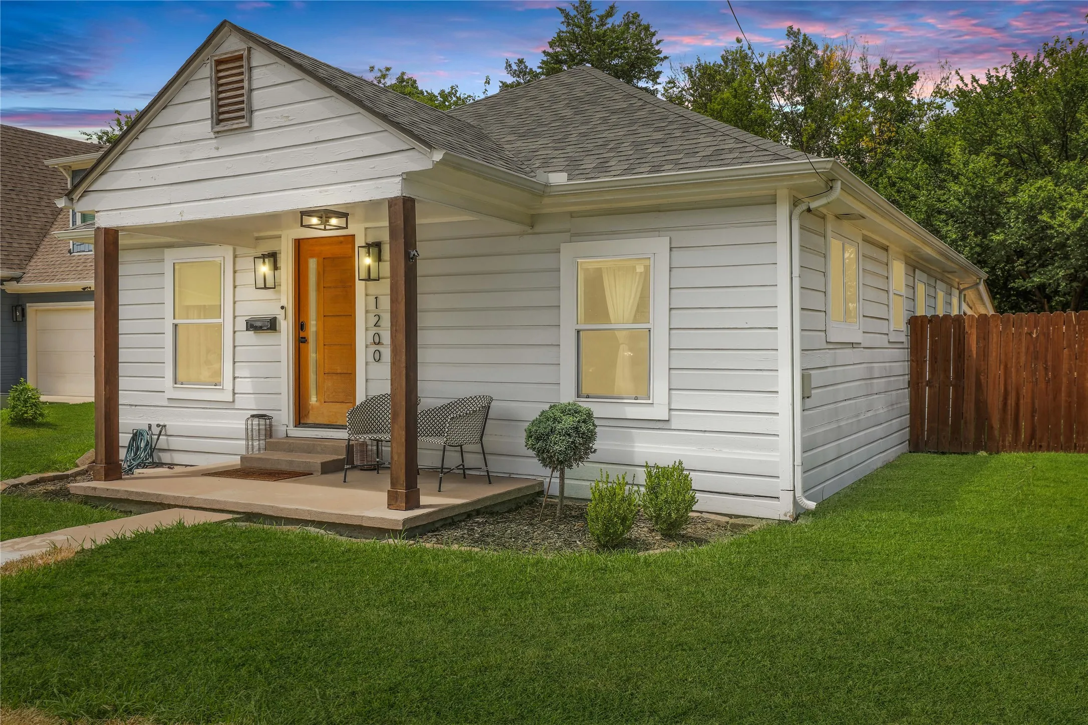 Charming single-story residence featuring light horizontal siding and a prominent front porch