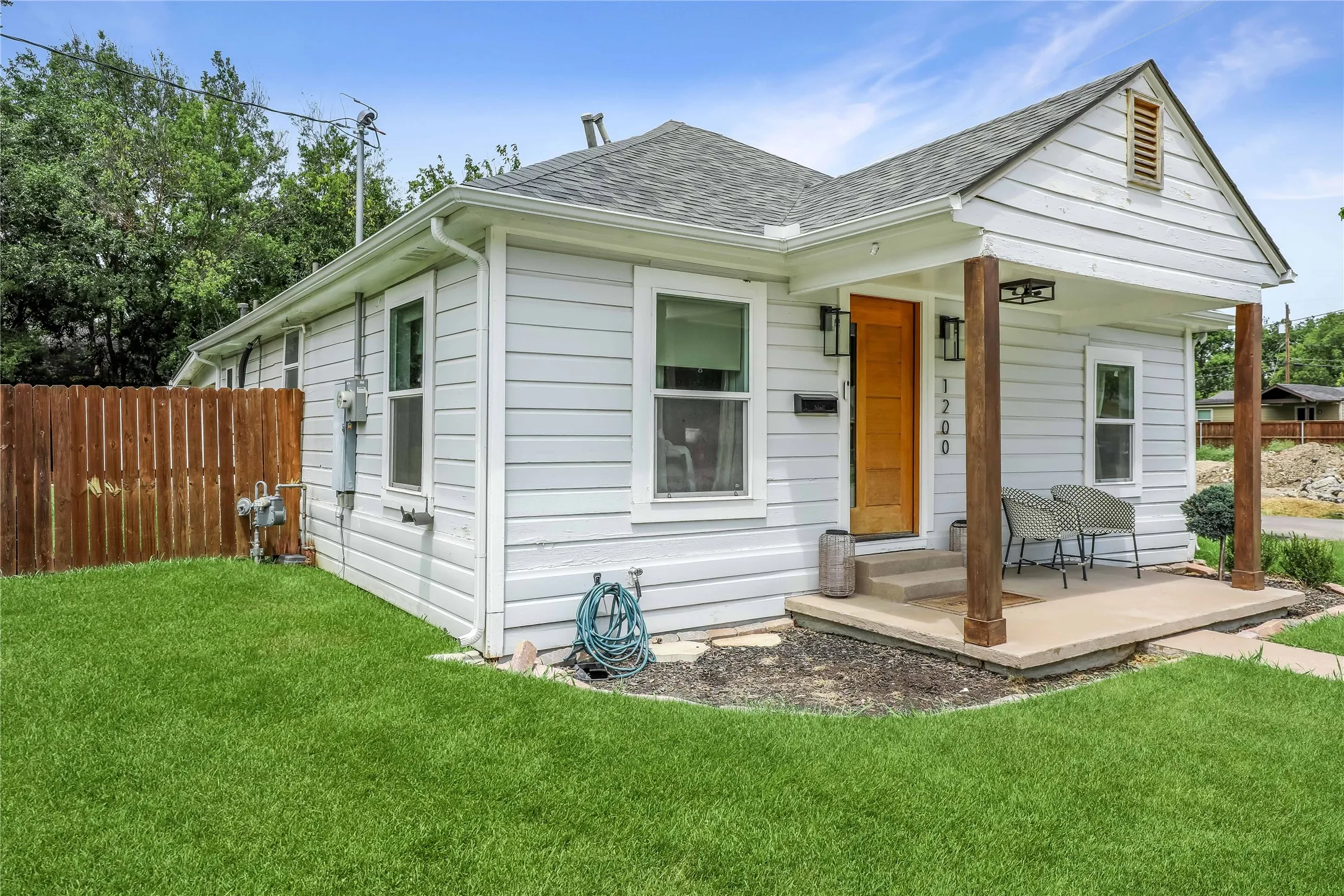 Light-colored horizontal siding exterior with a contrasting wood-finish entry door