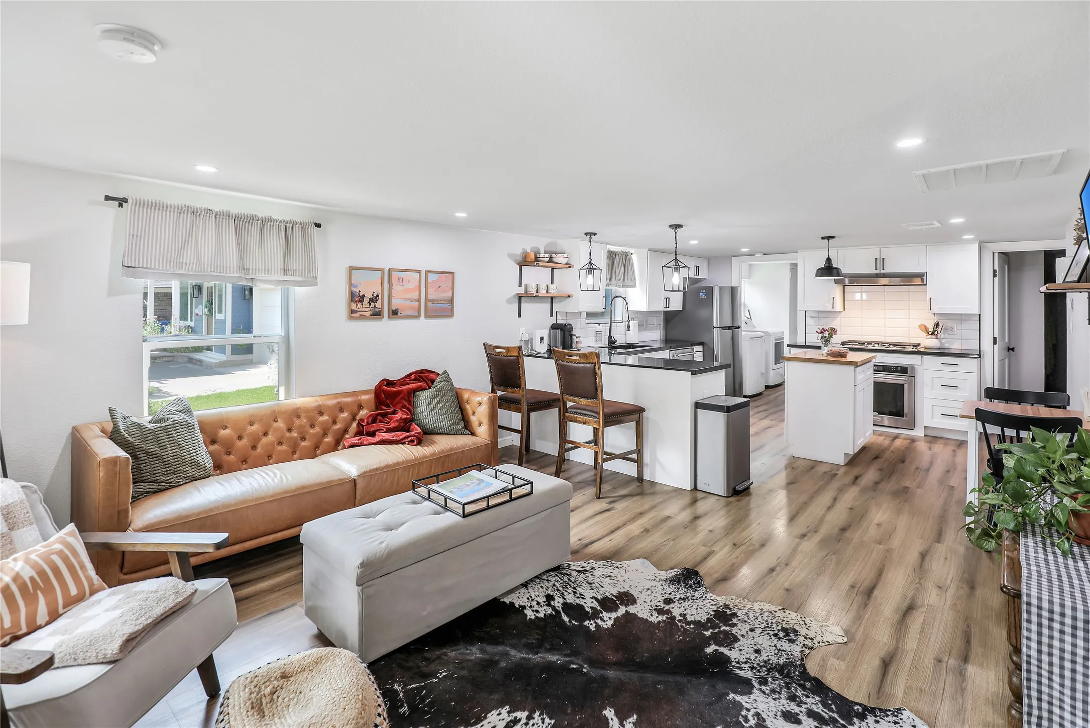 Open-concept living space featuring wood-finish flooring, recessed lighting, and white walls