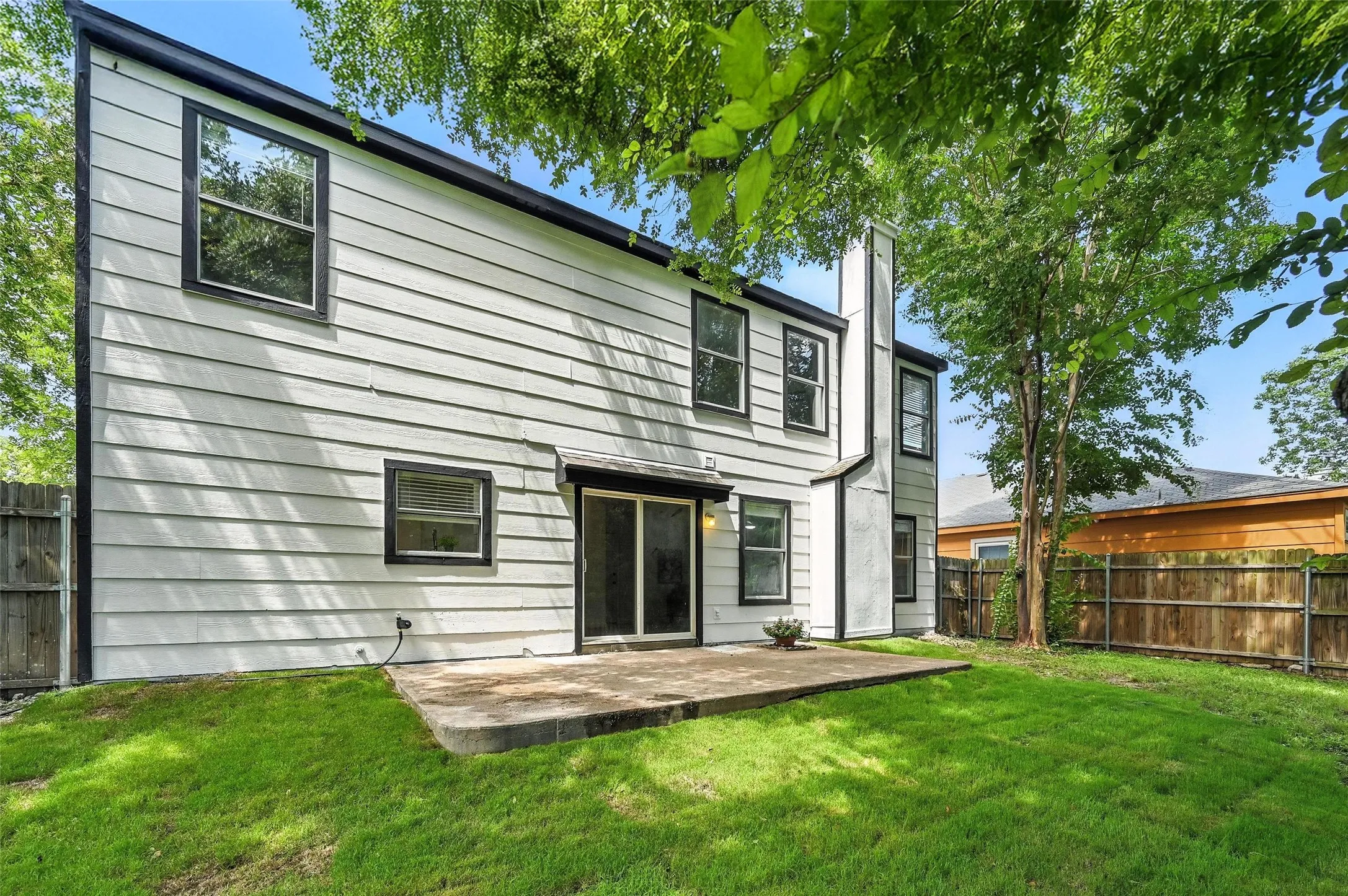 Back of house featuring a fenced backyard, a patio, and a chimney