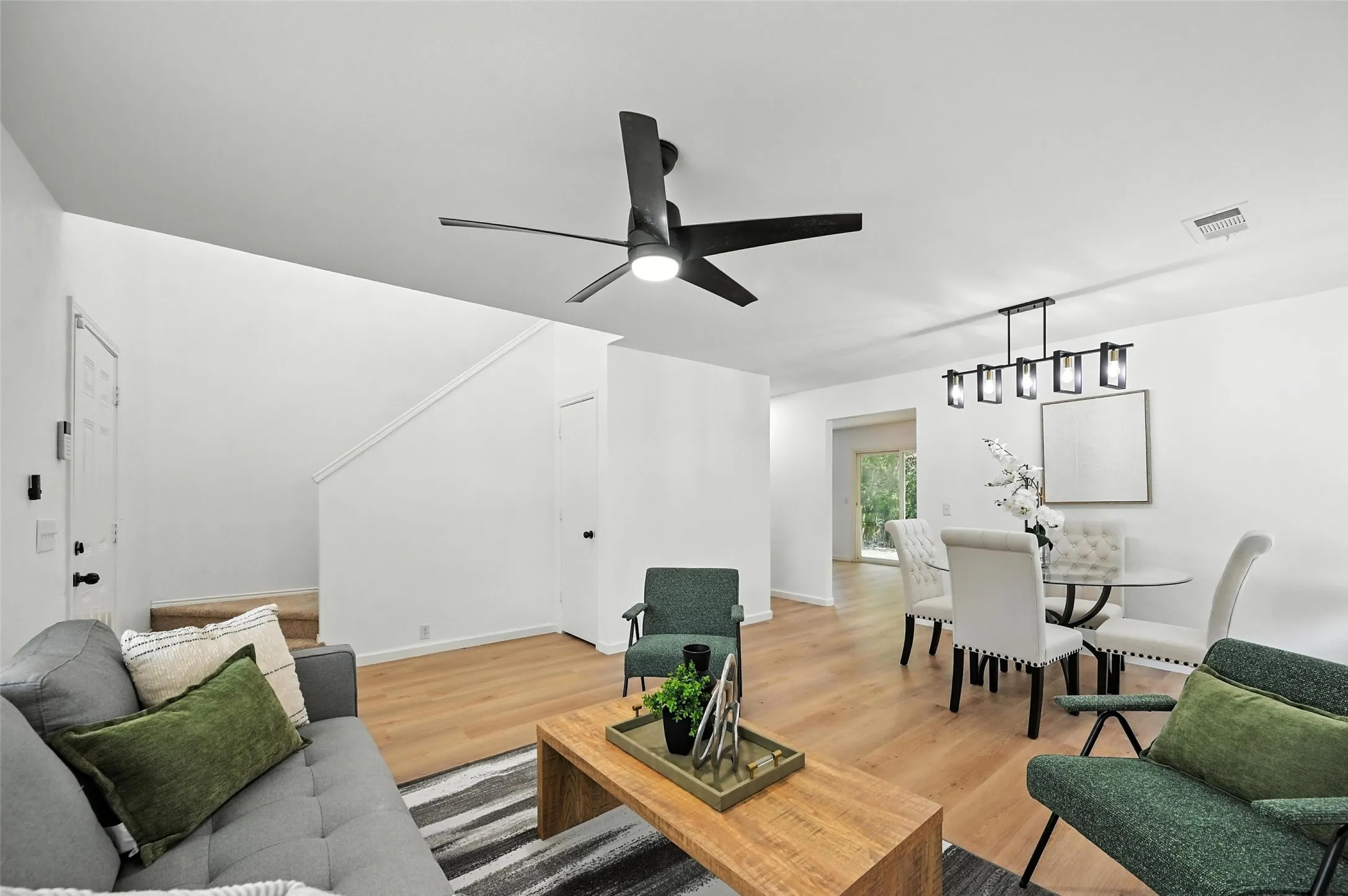Living room with light wood-style flooring and a ceiling fan
