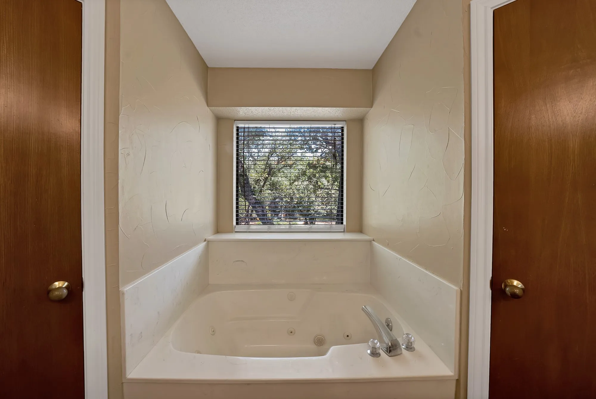 Built-in soaking tub with polished chrome fixtures and an integrated window