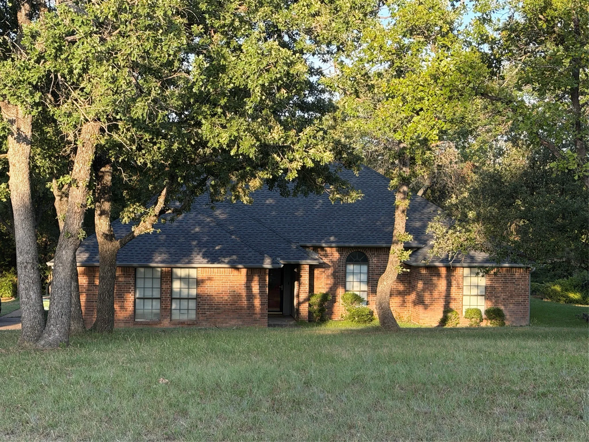 Brick exterior with an arched window accent and a dark shingle roof