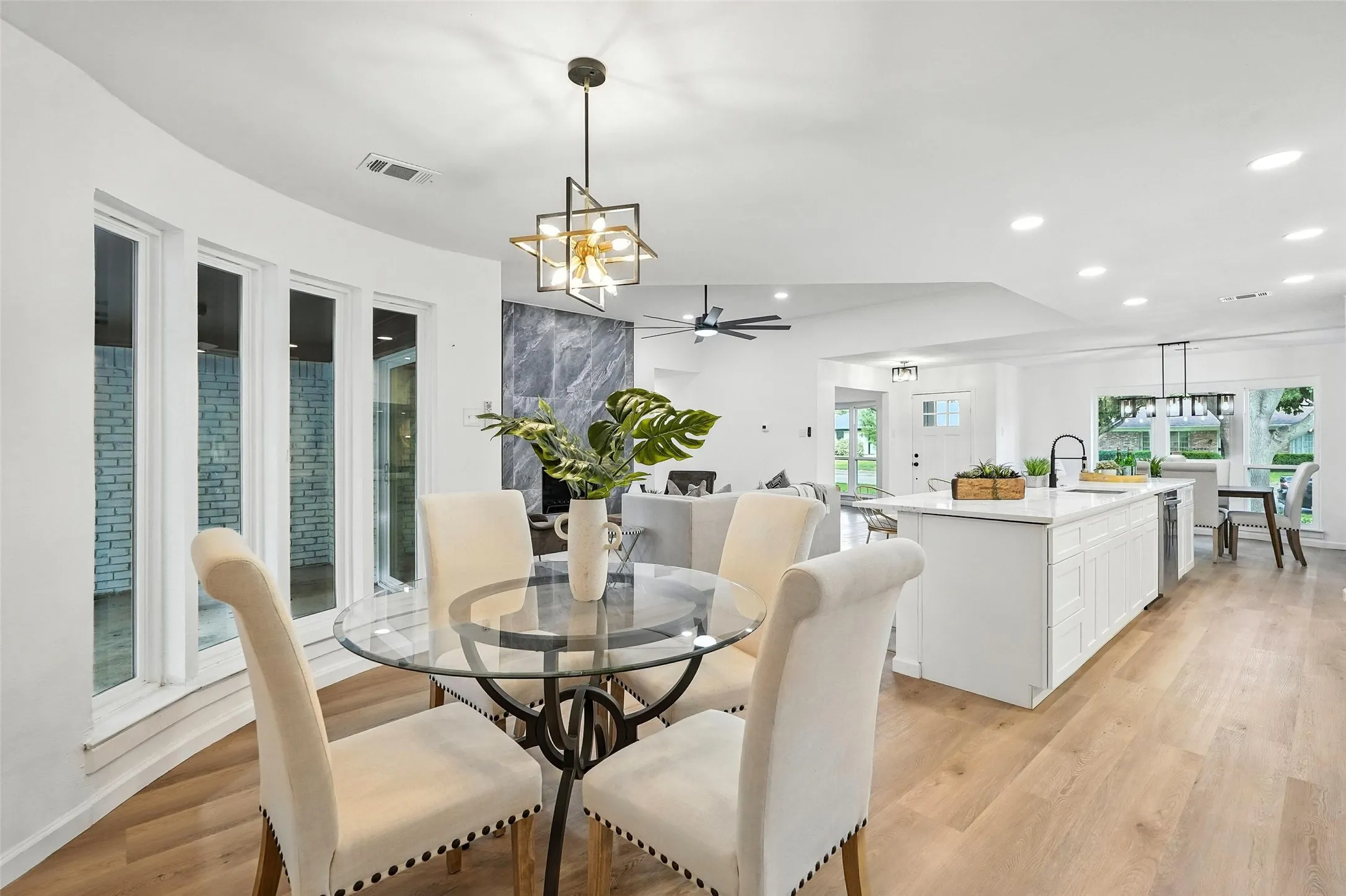 Dining space featuring a chandelier, a ceiling fan, light wood-style floors, and recessed lighting