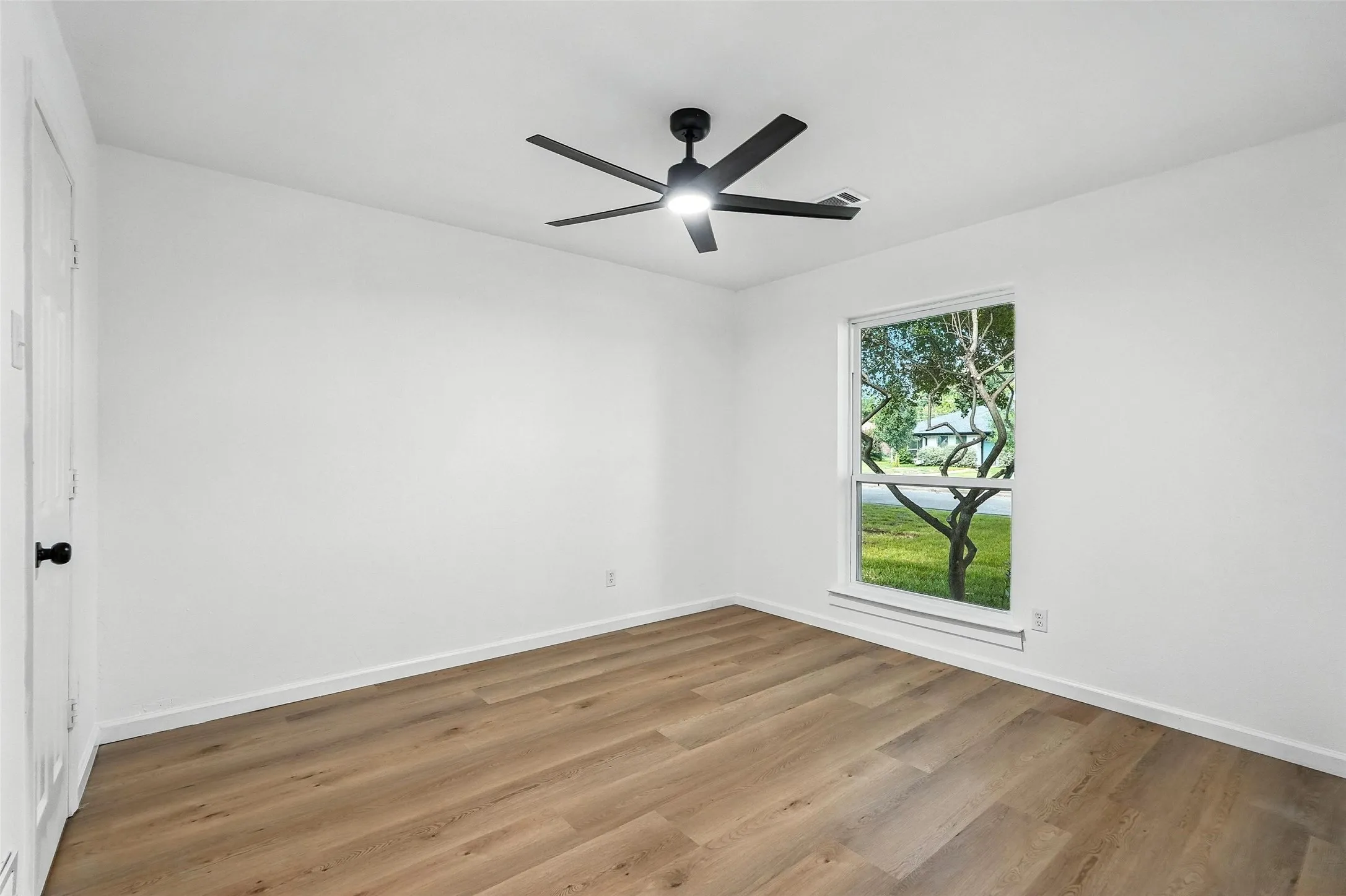 Unfurnished room featuring wood finished floors and ceiling fan