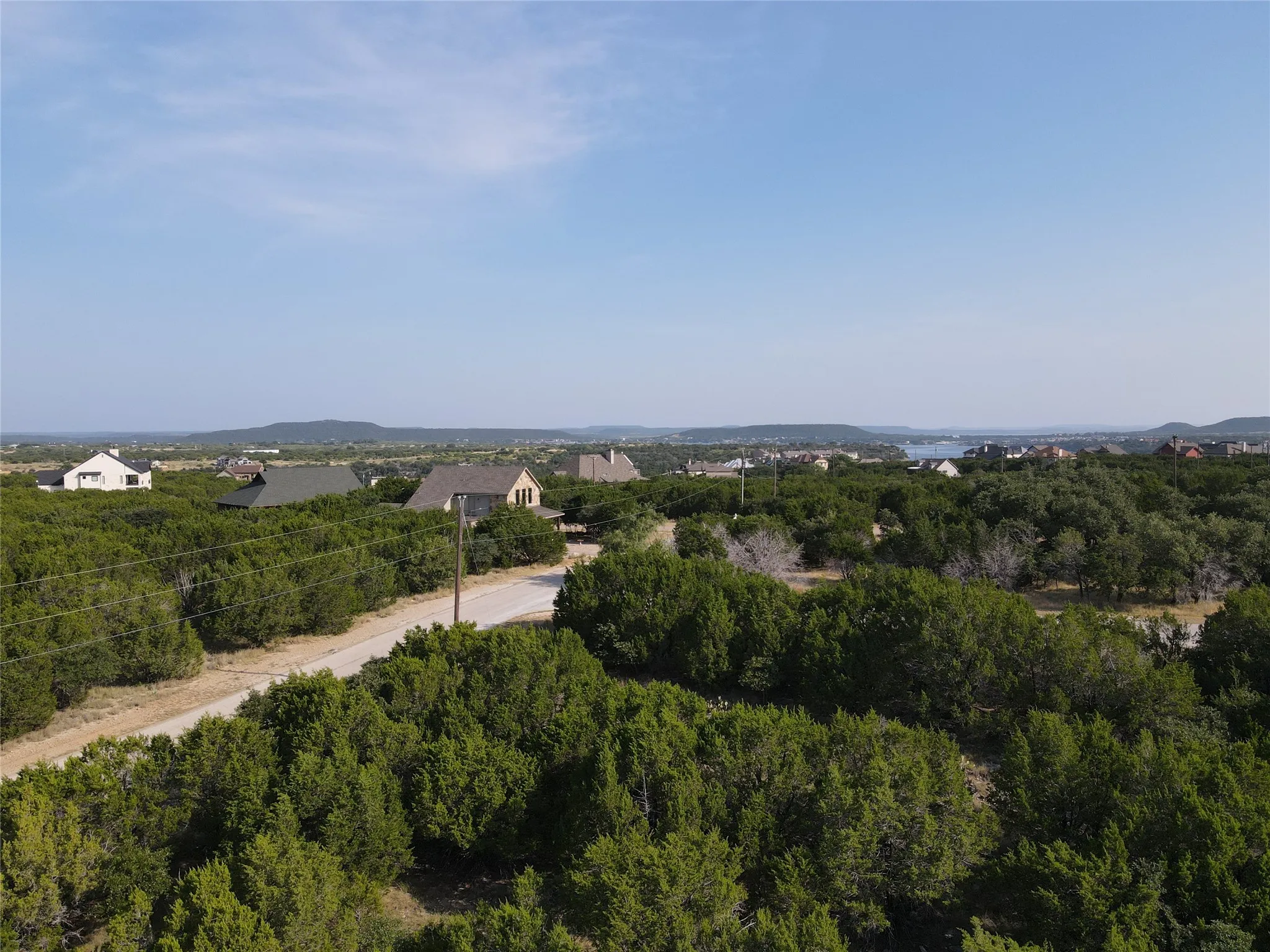 Expansive residential area with mature tree coverage and distant hills