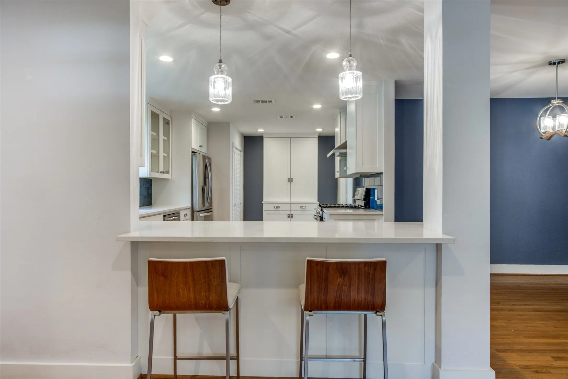 Kitchen bar with a white countertop and two pendant lights