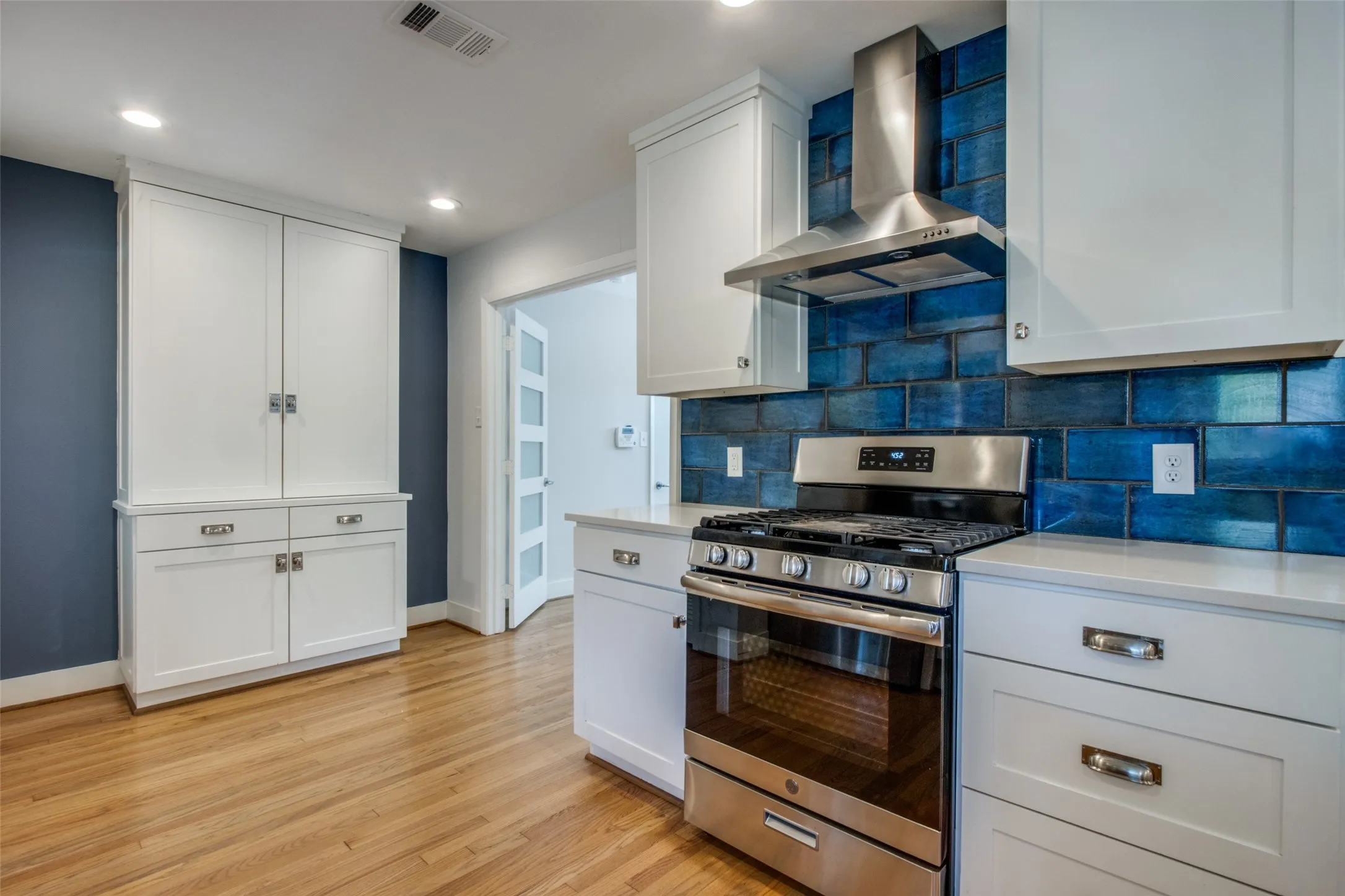 Modern kitchen featuring a stainless steel gas range with a matching range hood