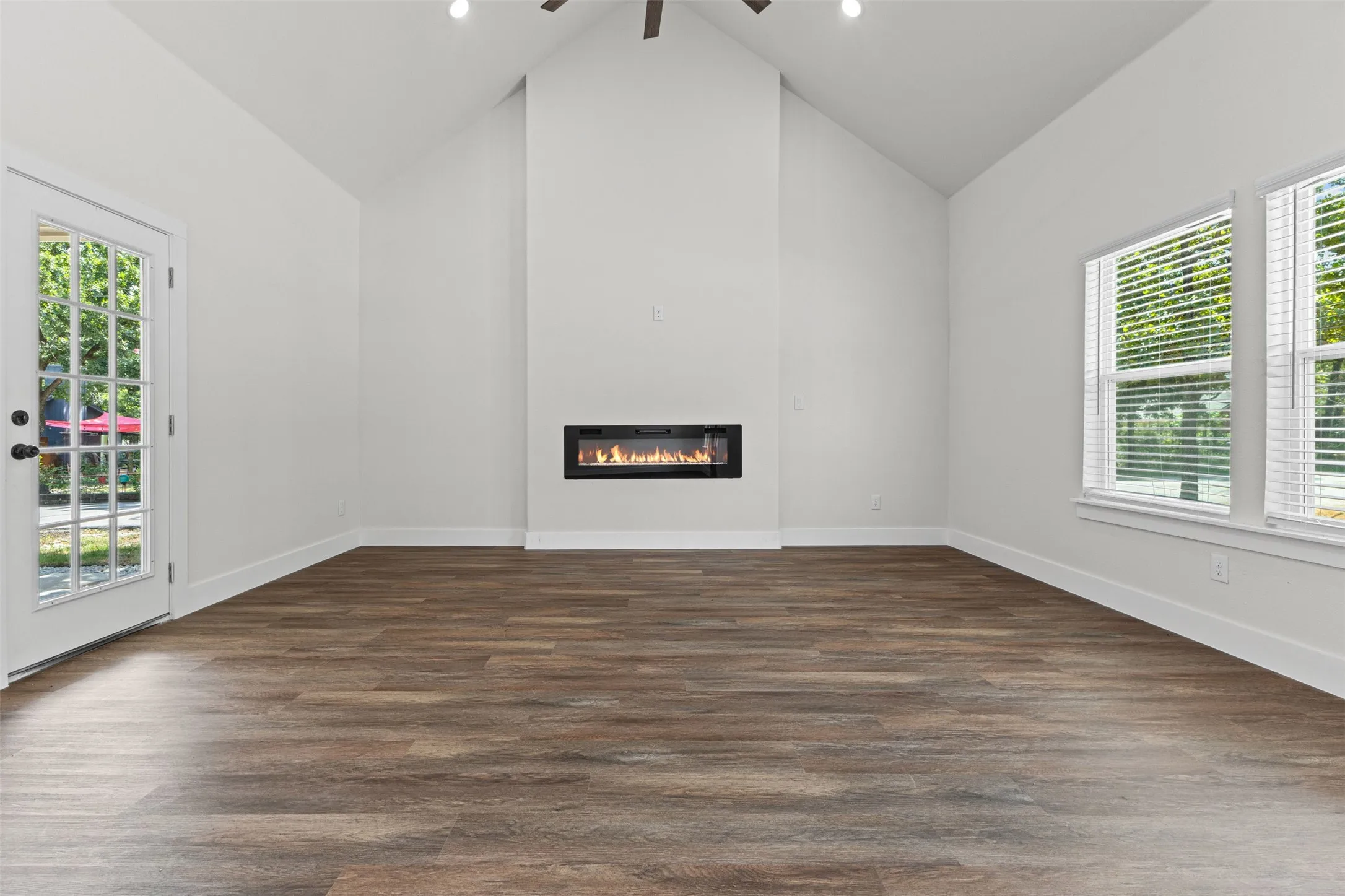 Living space featuring vaulted ceilings, a built-in fireplace, and wood-finish flooring